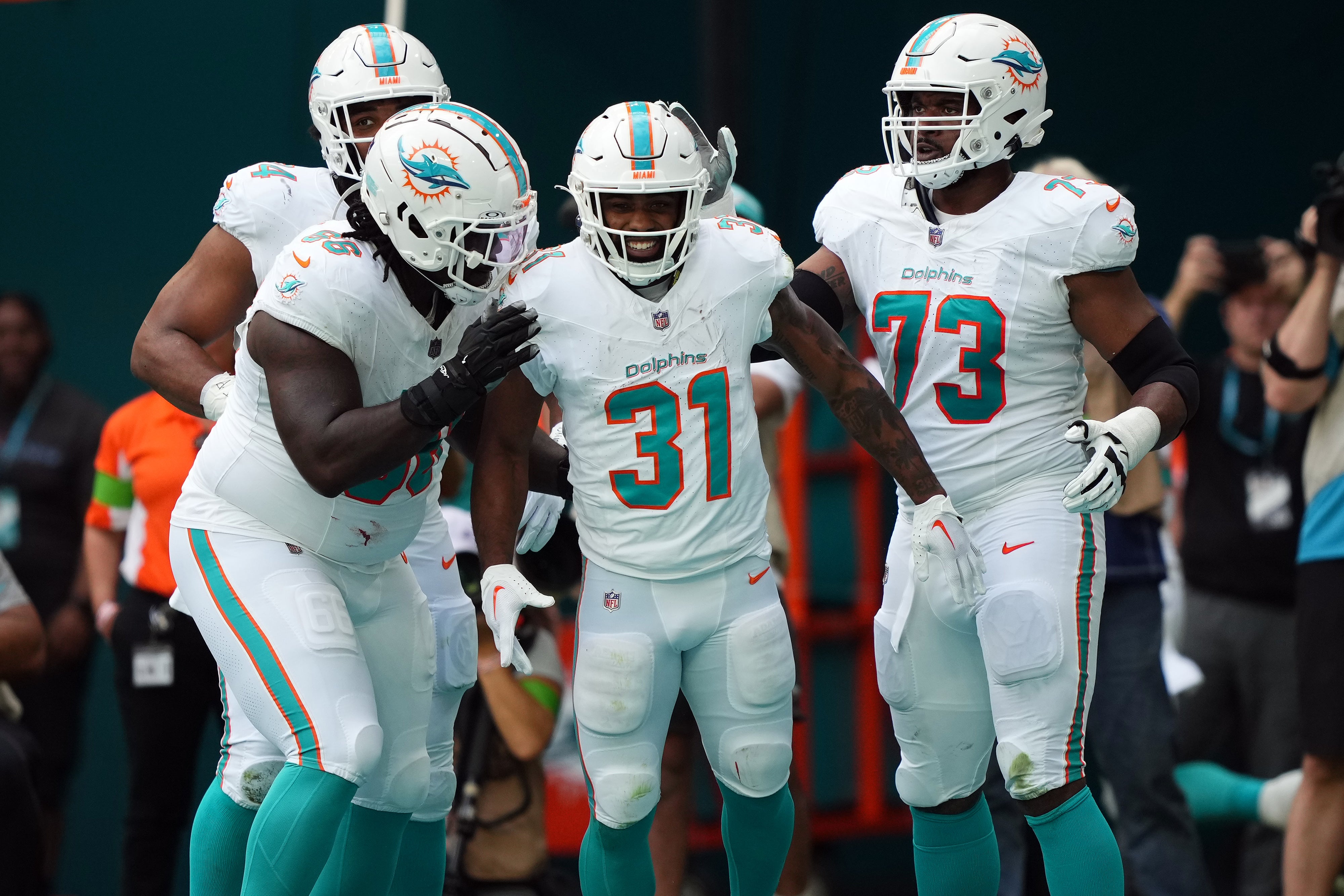 Caption: Dec 17, 2023; Miami Gardens, Florida, USA; Miami Dolphins running back Raheem Mostert (31) celebrates with teammates after scoring a touchdown against the New York Jets during the first half at Hard Rock Stadium.