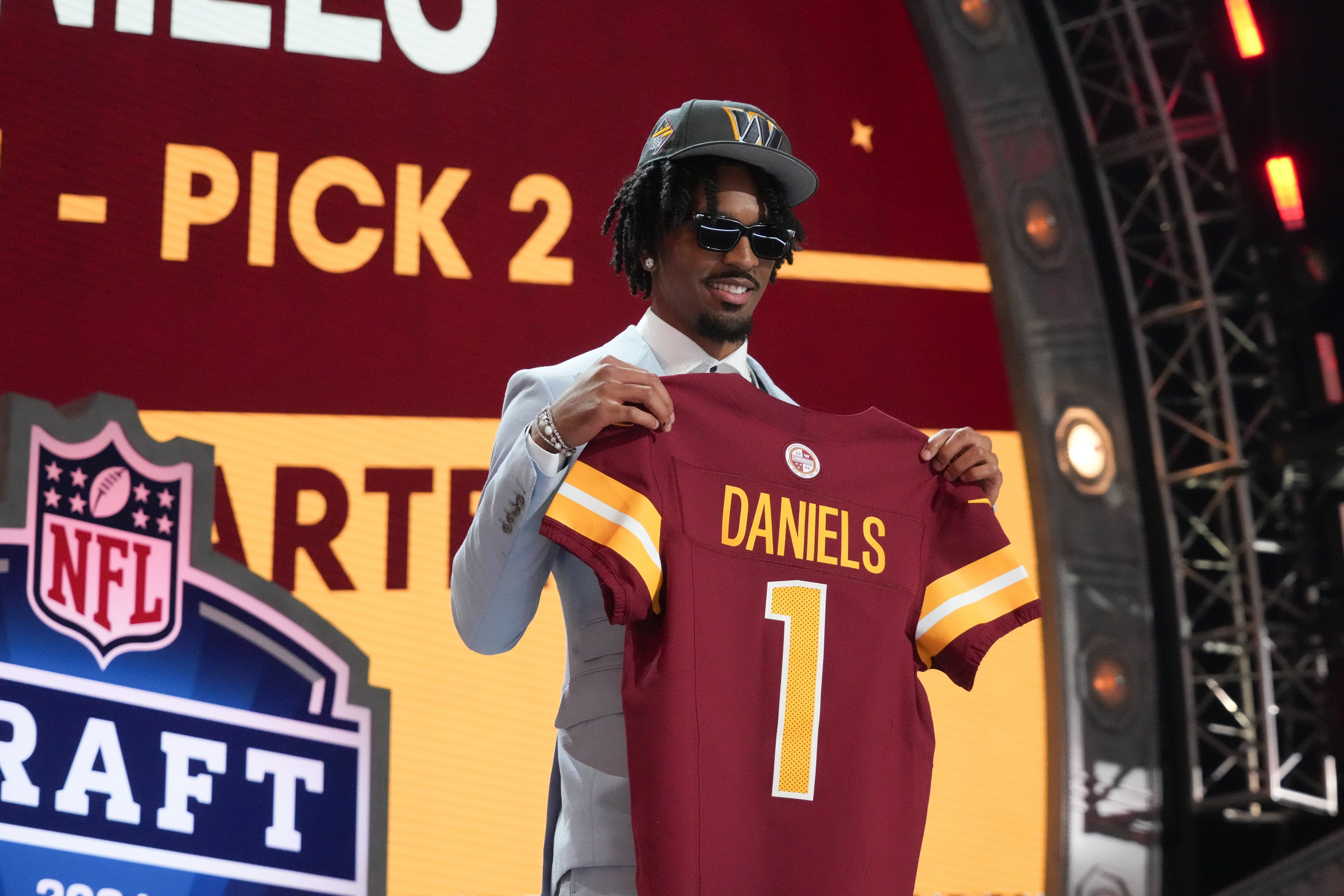 Apr 25, 2024; Detroit, MI, USA; LSU Tigers quarterback Jayden Daniels poses after being selected by the Washington Commanders as the No. 2 pick in the first round of the 2024 NFL Draft at Campus Martius Park and Hart Plaza.