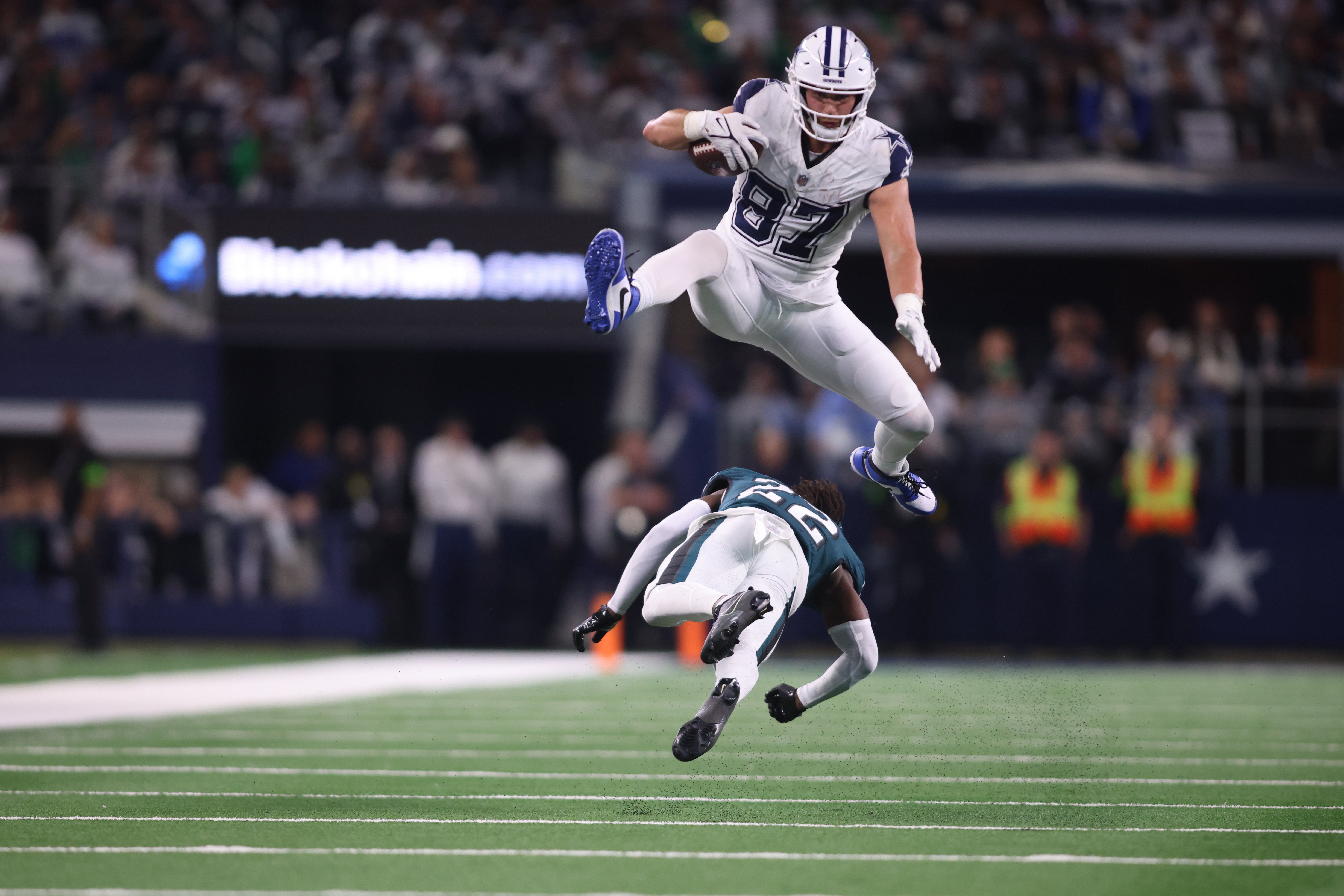 Dallas Cowboys tight end Jake Ferguson (87) jumps over Philadelphia Eagles cornerback Kelee Ringo (22) in the fourth quarter at AT&T Stadium.