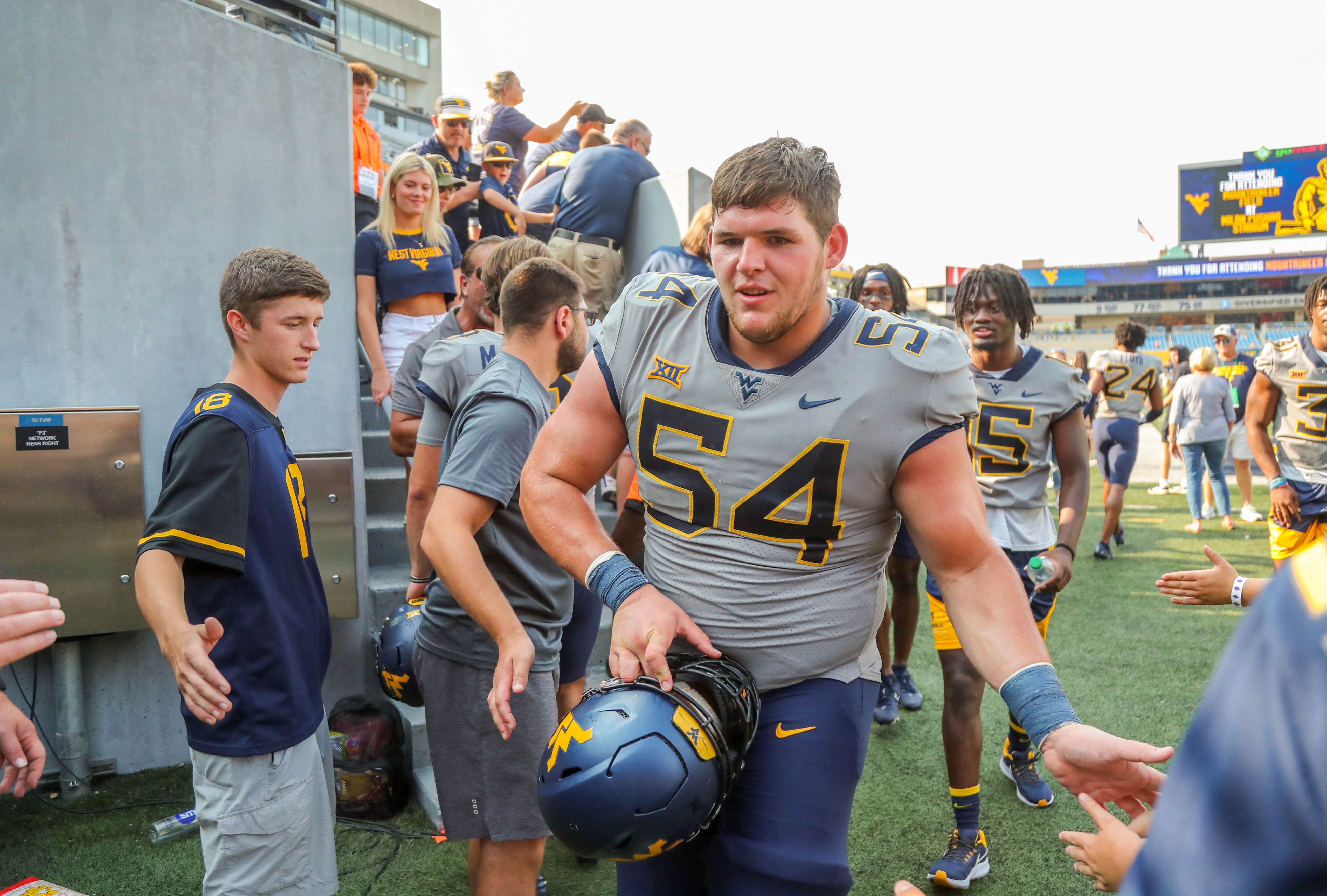 Sep 17, 2022; Morgantown, West Virginia, USA; West Virginia Mountaineers offensive lineman Zach Frazier (54) celebrates with fans after defeating the Towson Tigers at Mountaineer Field at Milan Puskar Stadium. Mandatory Credit: Ben Queen-USA TODAY Sports  