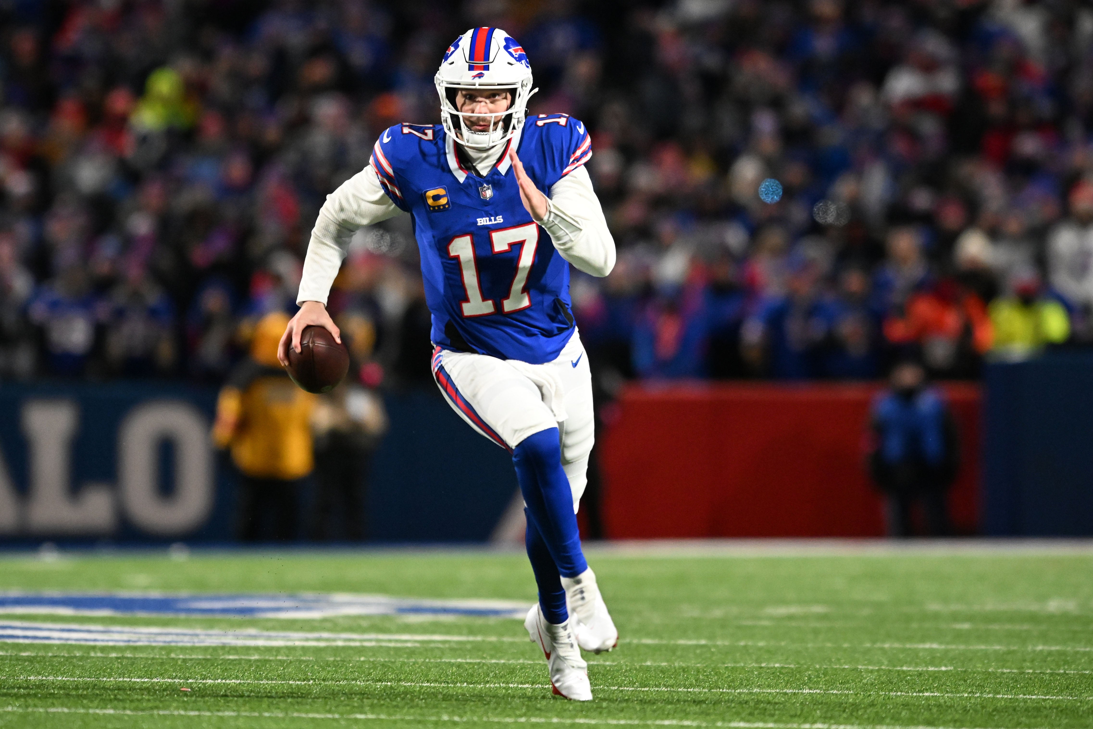 Buffalo Bills quarterback Josh Allen (17) rushes the ball against the Kansas City Chiefs in the first half of the 2024 AFC divisional round game at Highmark Stadium.