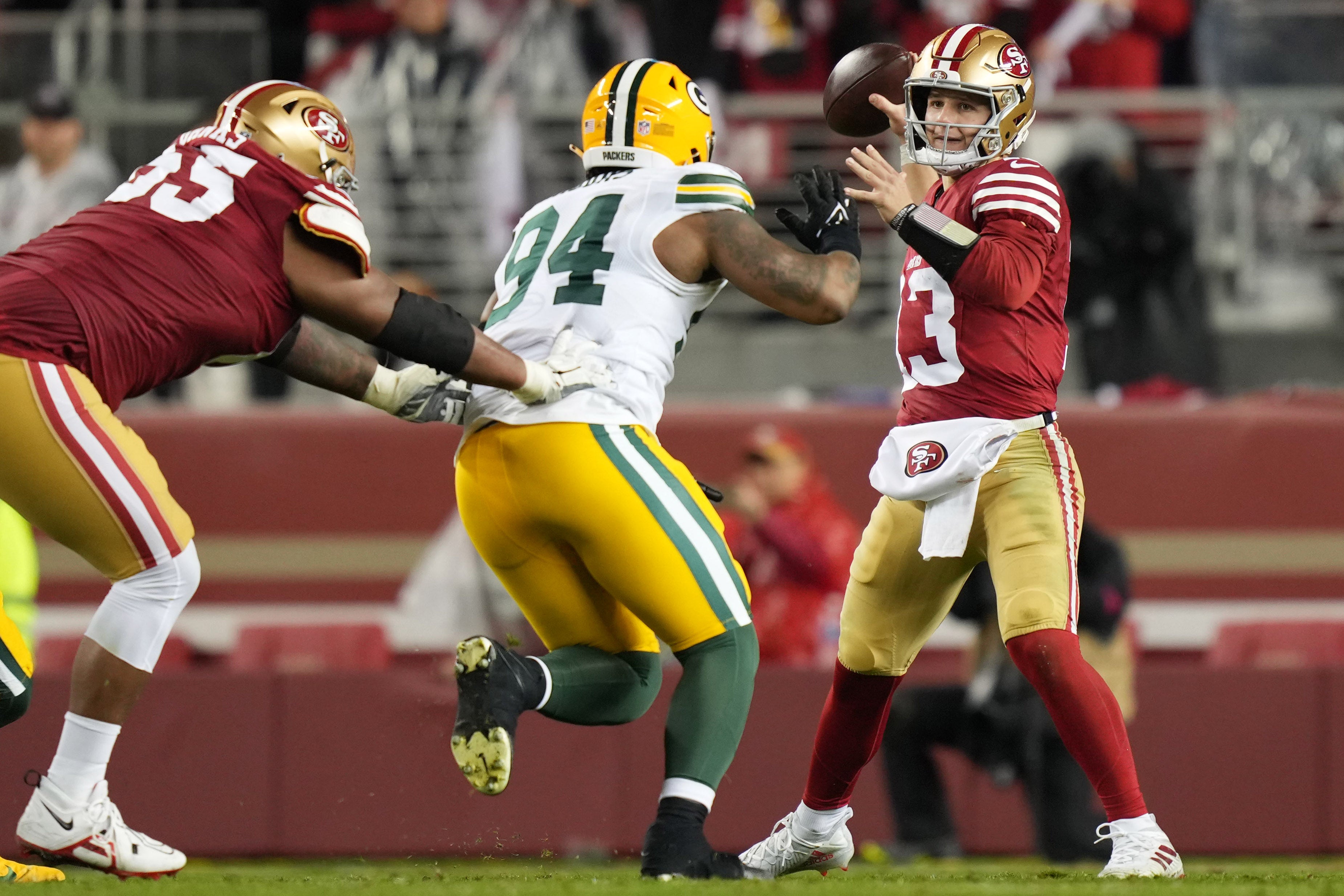 January 20, 2024; Santa Clara, CA, USA; San Francisco 49ers quarterback Brock Purdy (13) passes under pressure from Green Bay Packers defensive end Karl Brooks (94) during the third quarter in a 2024 NFC divisional round game at Levi's Stadium.