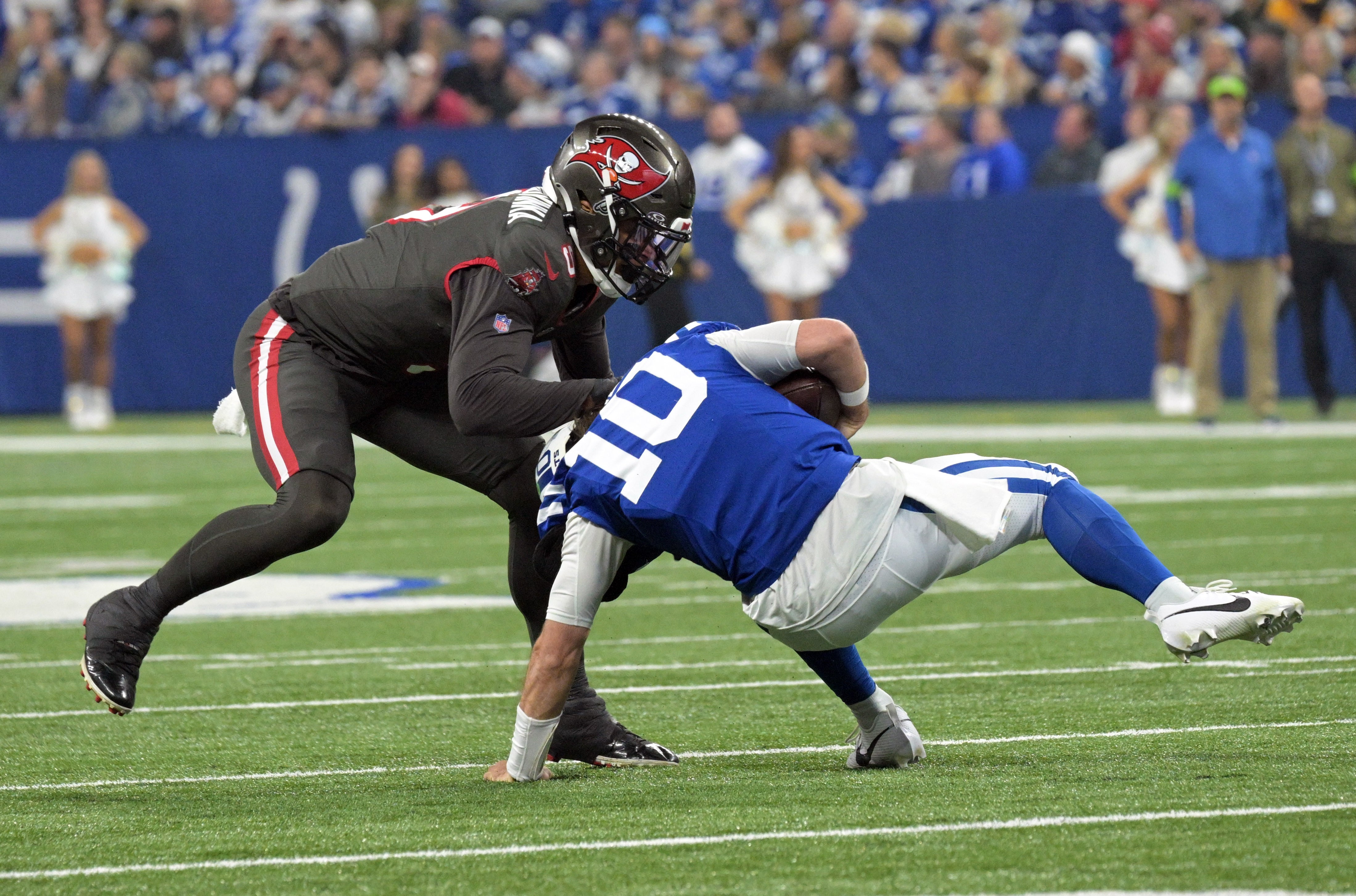 Nov 26, 2023; Indianapolis, Indiana, USA; Indianapolis Colts quarterback Gardner Minshew (10) is sacked by Tampa Bay Buccaneers linebacker Joe Tryon-Shoyinka (9) during the second quarter at Lucas Oil Stadium.