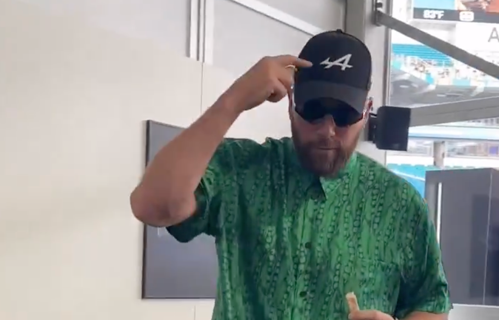 Travis Kelce wears a BWT Alpine F1 Team at the Miami Grand Prix, while Taylor Swift plays in the background.