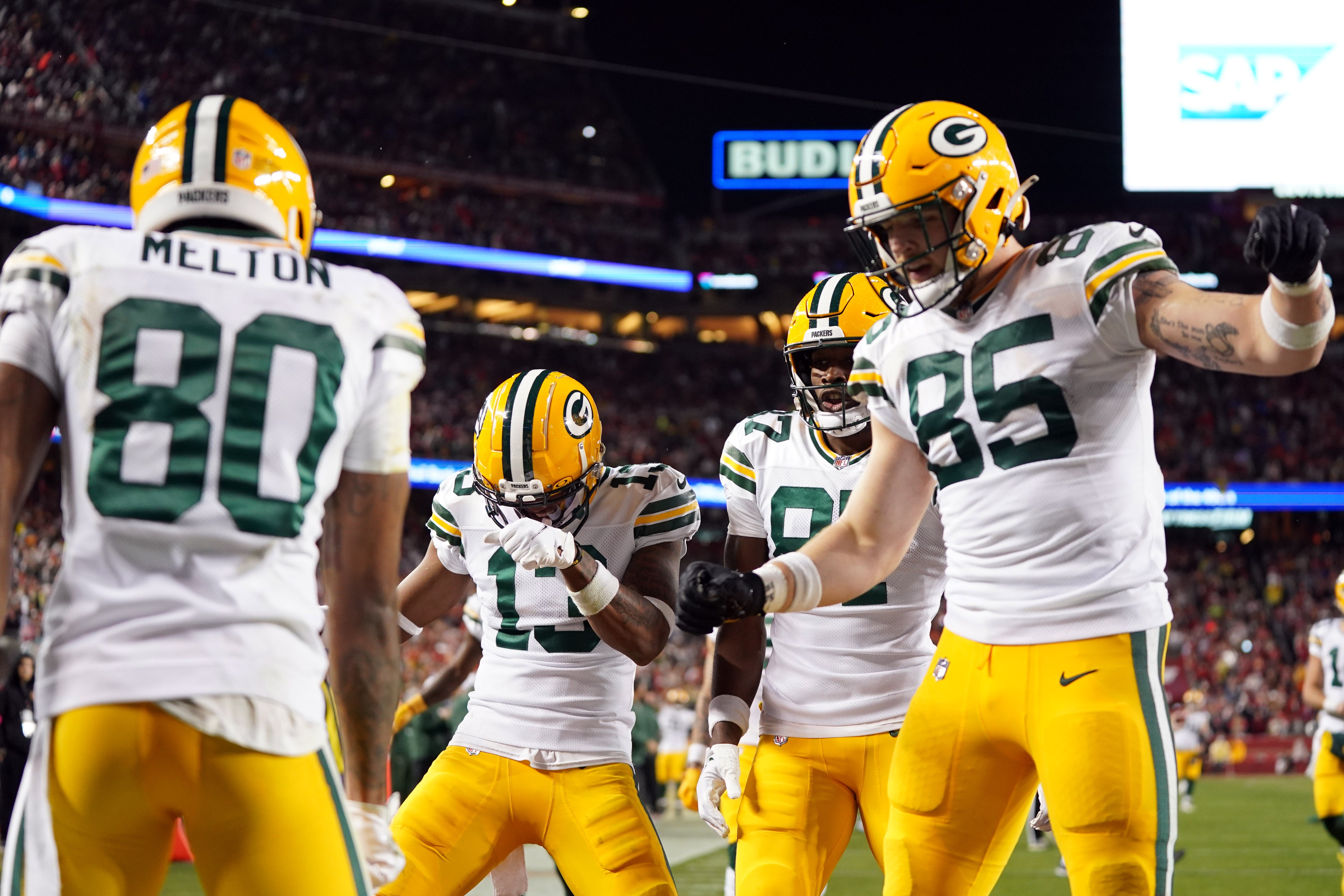 Green Bay Packers wide receiver Dontayvion Wicks (13) and wide receiver Romeo Doubs (87) and tight end Tucker Kraft (85) celebrate after wide receiver Bo Melton (80)