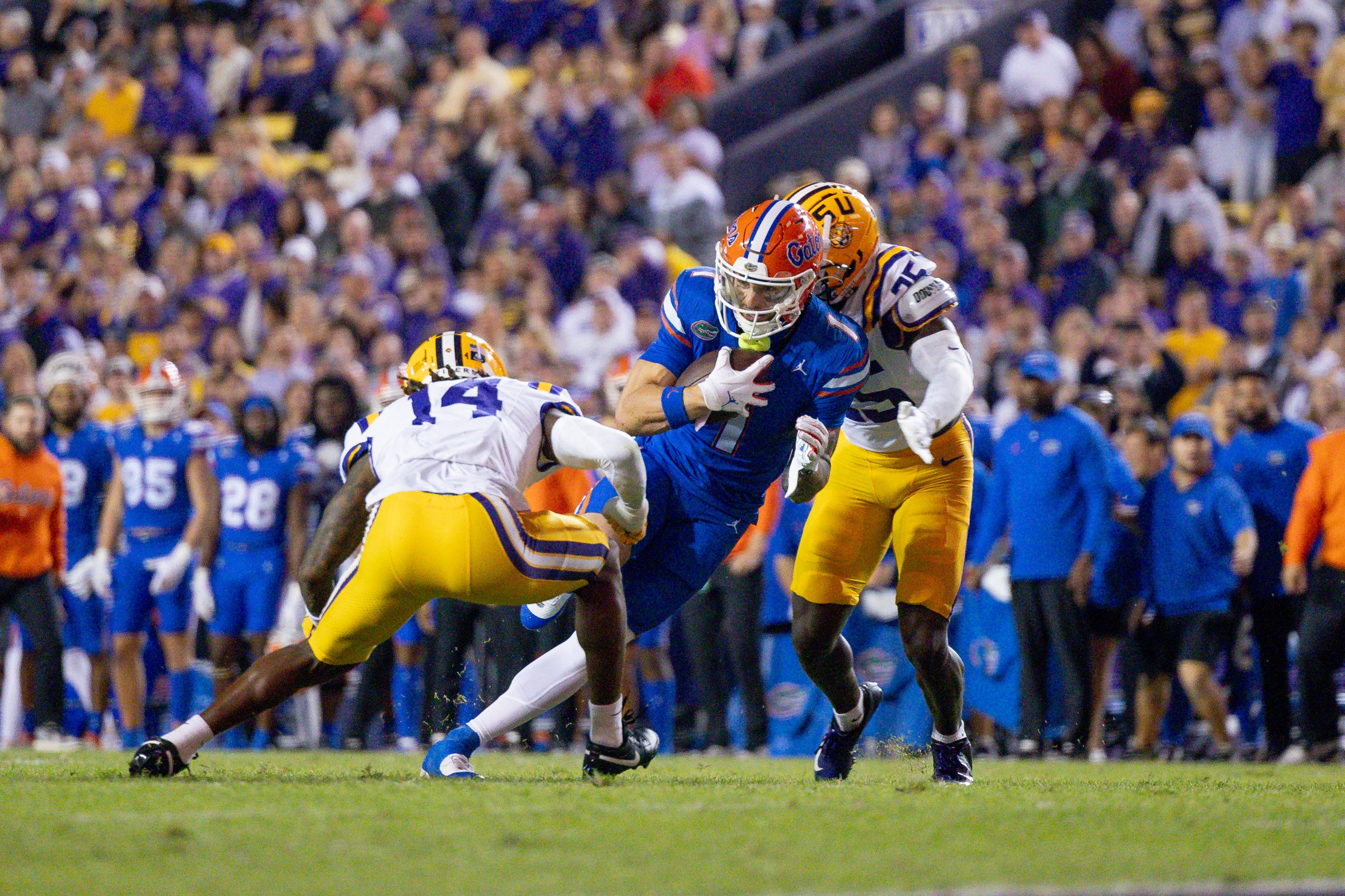 Nov 11, 2023; Baton Rouge, Louisiana, USA; Florida Gators wide receiver Ricky Pearsall (1) is tackled by LSU Tigers safety Andre' Sam (14) and safety Javien Toviano (25) during the first half at Tiger Stadium.