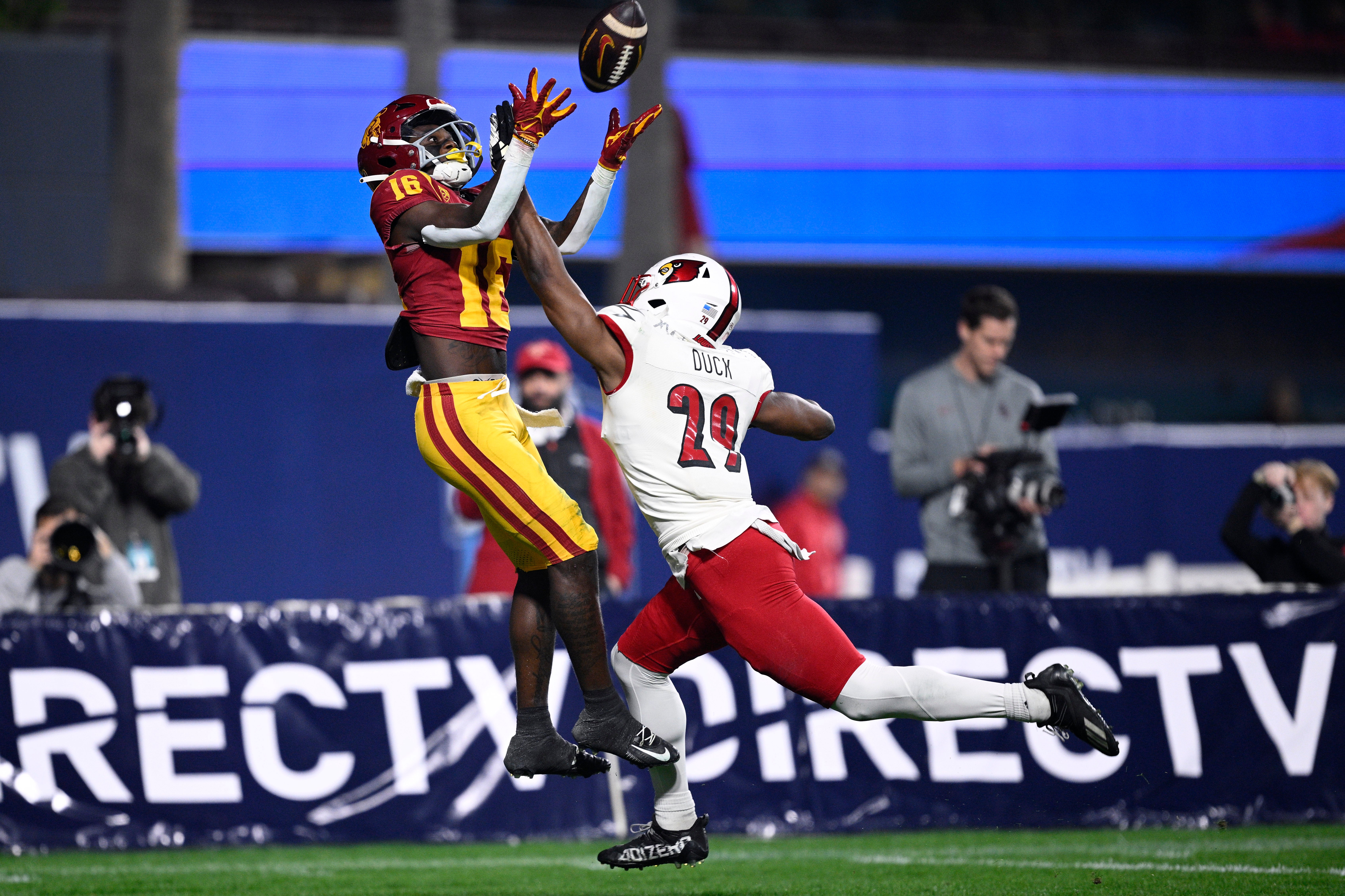 Dec 27, 2023; San Diego, CA, USA; USC Trojans wide receiver Tahj Washington (16) catches a touchdown over Louisville Cardinals defensive back Storm Duck (29) during the first half at Petco Park.