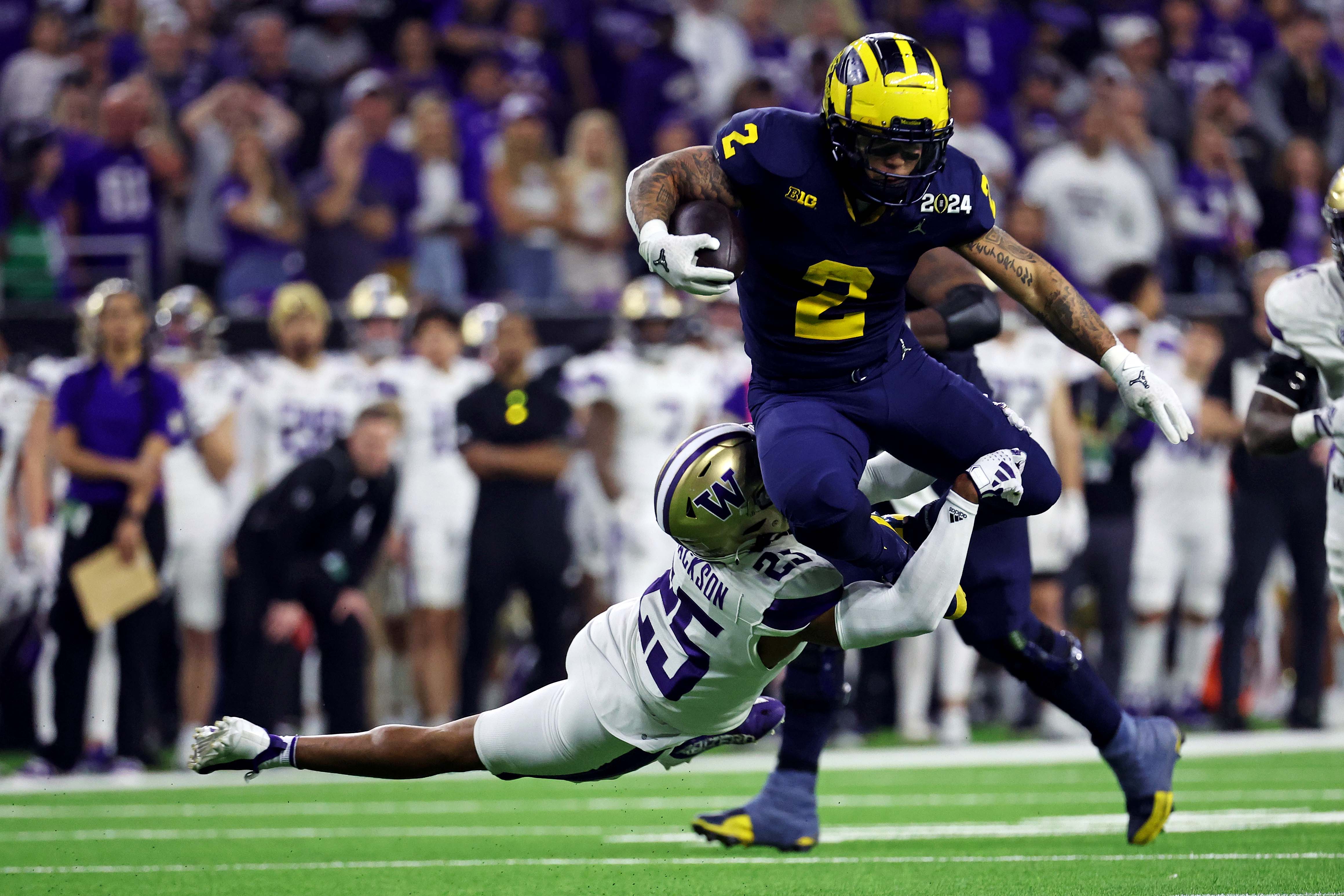 Jan 8, 2024; Houston, TX, USA; Michigan Wolverines running back Blake Corum (2) runs the ball against Washington Huskies cornerback Elijah Jackson (25) during the third quarter in the 2024 College Football Playoff national championship game at NRG Stadium. Mandatory Credit: Troy Taormina-USA TODAY Sports