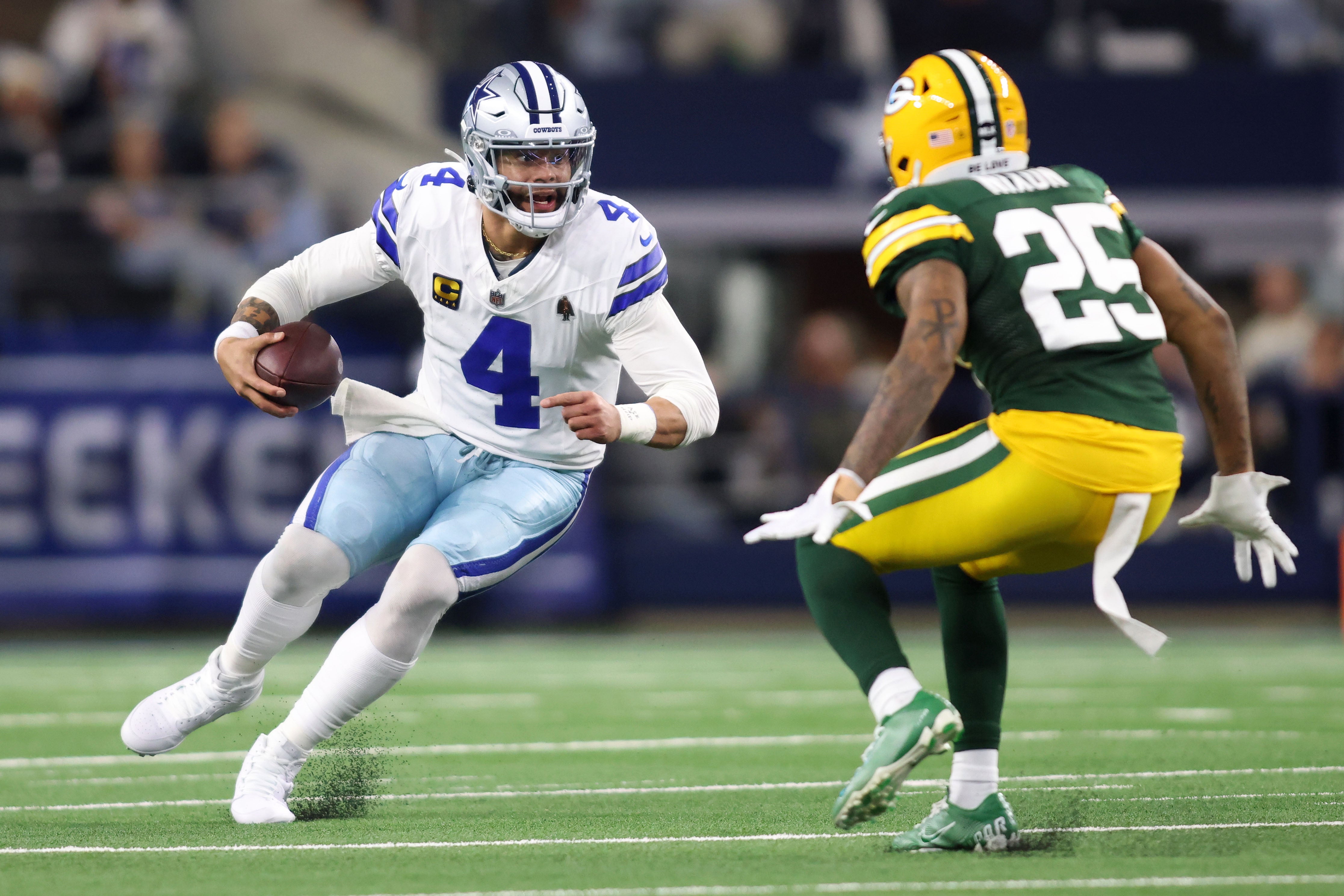 Dallas Cowboys quarterback Dak Prescott (4) rushes the ball against Green Bay Packers cornerback Keisean Nixon (25) during the second half of the 2024 NFC wild card game at AT&T Stadium.