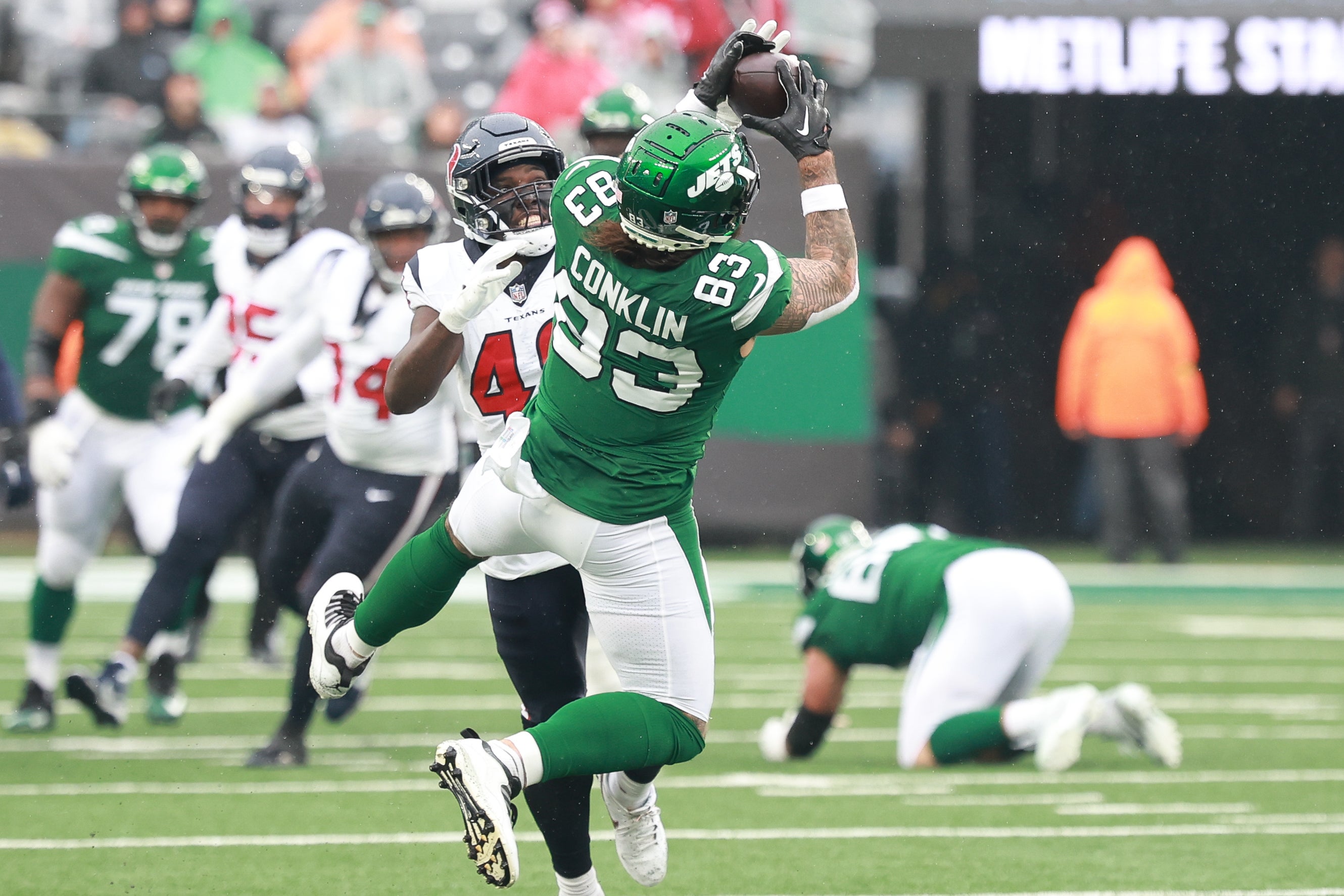 New York Jets tight end Tyler Conklin (83) makes a catch in front of Houston Texans linebacker Christian Harris (48) during the first half at MetLife Stadium.