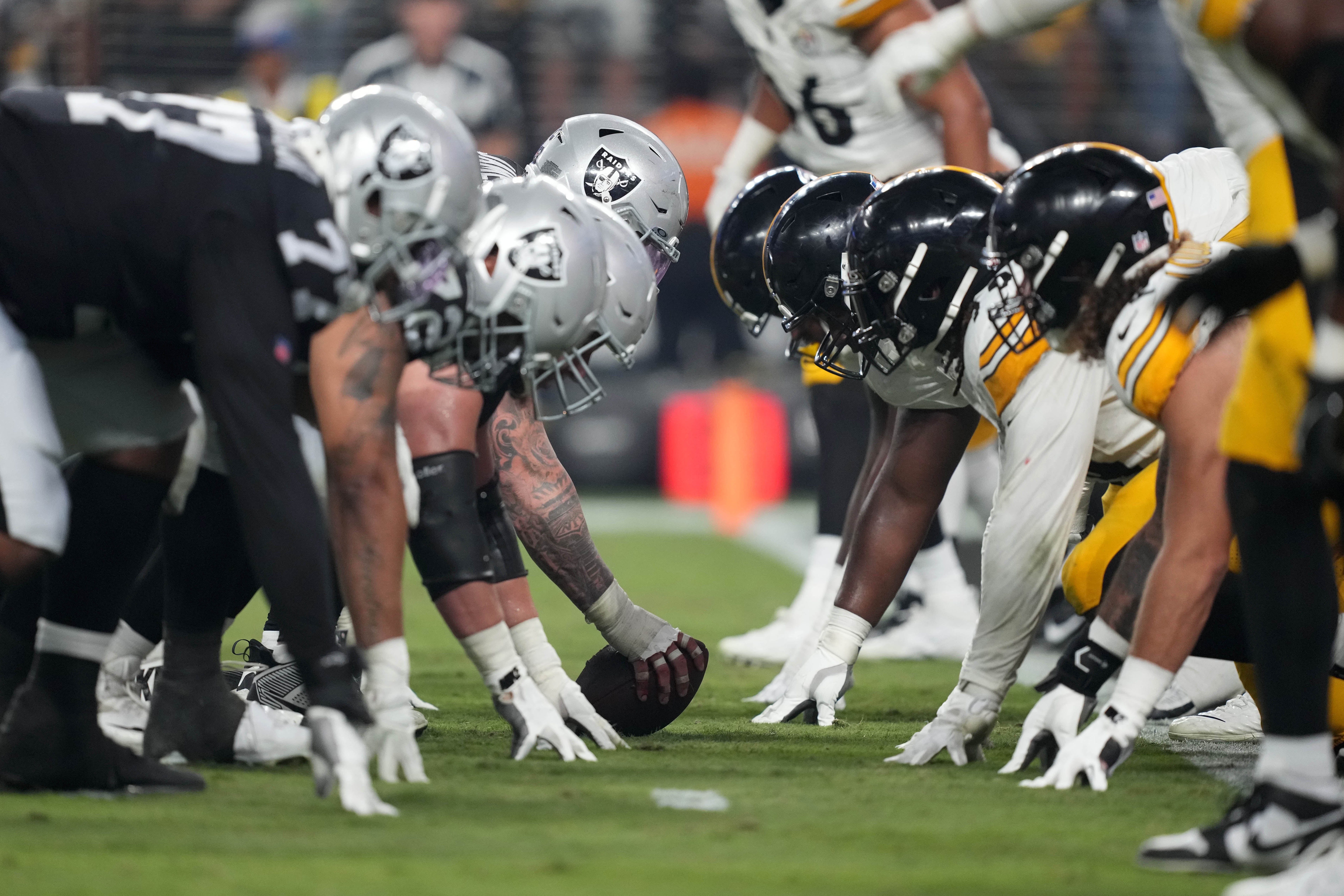Sep 24, 2023; Paradise, Nevada, USA; A general overall ivew of helmets at the line of scrimmage as Las Vegas Raiders center Andre James (68) snaps the ball against the Pittsburgh Steelers at Allegiant Stadium. Mandatory Credit: Kirby Lee-USA TODAY Sports