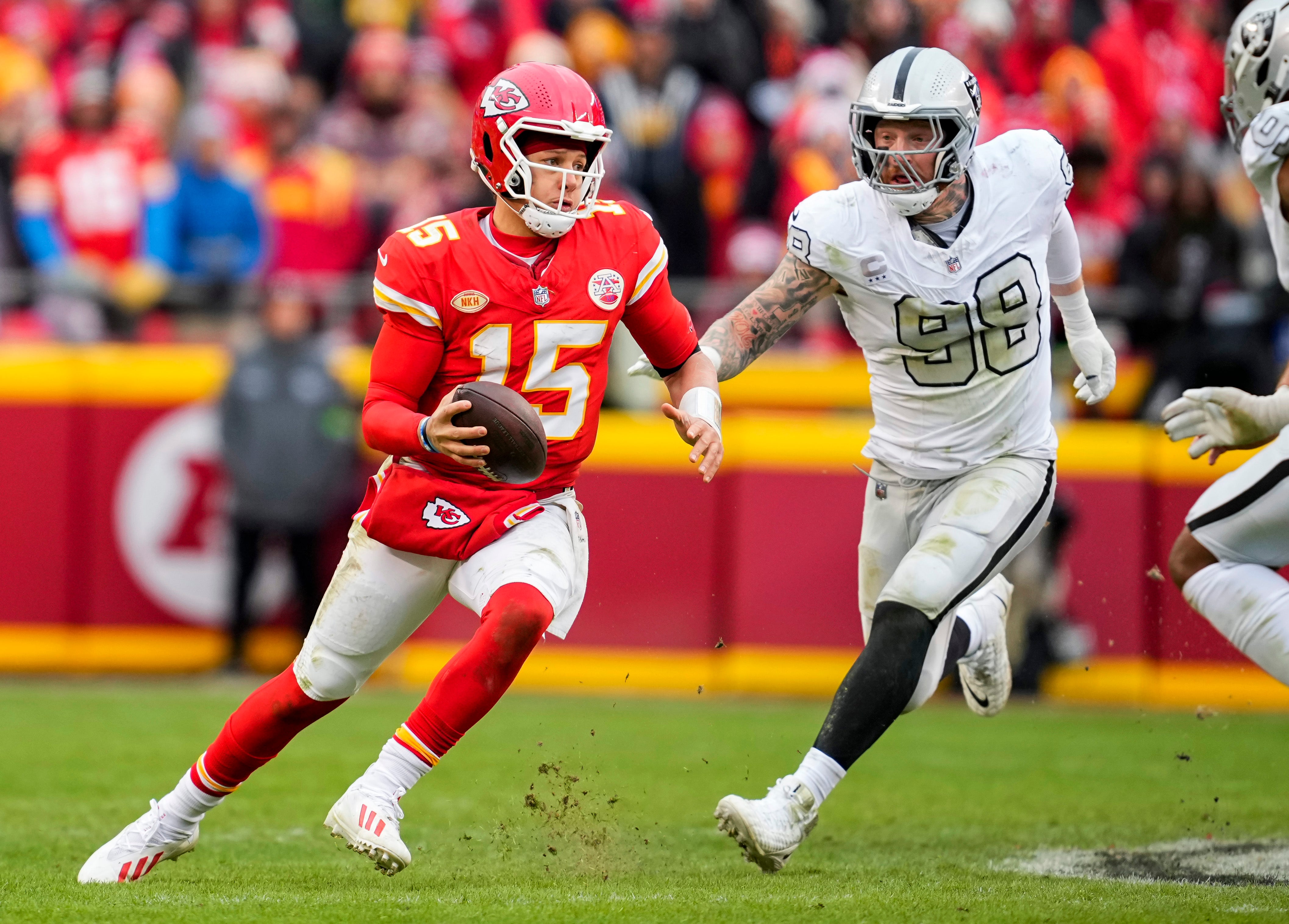 Dec 25, 2023; Kansas City, Missouri, USA; Kansas City Chiefs quarterback Patrick Mahomes (15) scrambles against Las Vegas Raiders defensive end Maxx Crosby (98) during the second half at GEHA Field at Arrowhead Stadium.