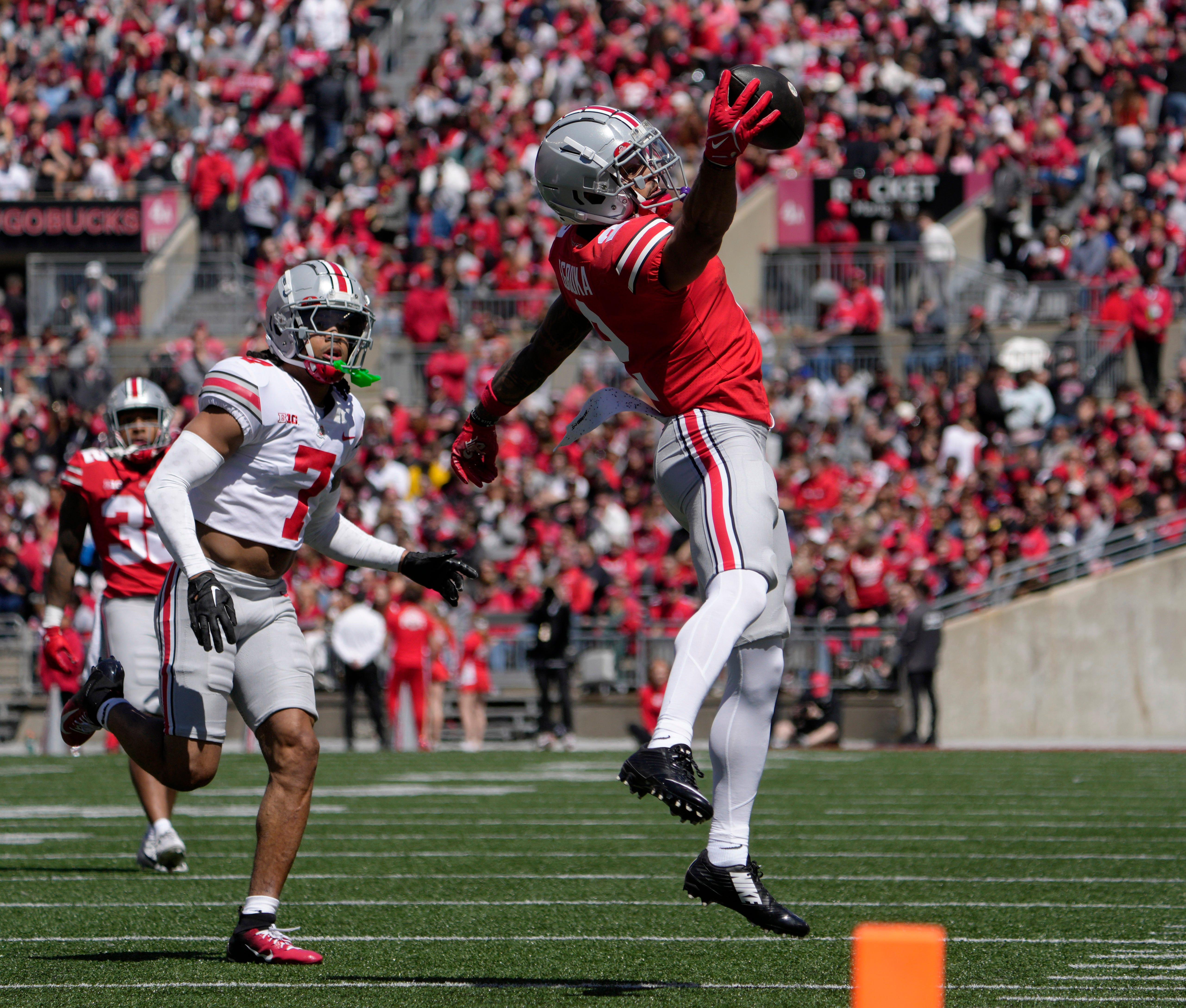 April 13, 2024; Columbus, Ohio, USA; Ohio State Buckeyes wide receiver Emeka Egbuka (2) catches a pass for the scarlet team while defended by cornerback Jordan Hancock (7) of the grey team during the first half of the LifeSports Spring Game at Ohio Stadium on Saturday.