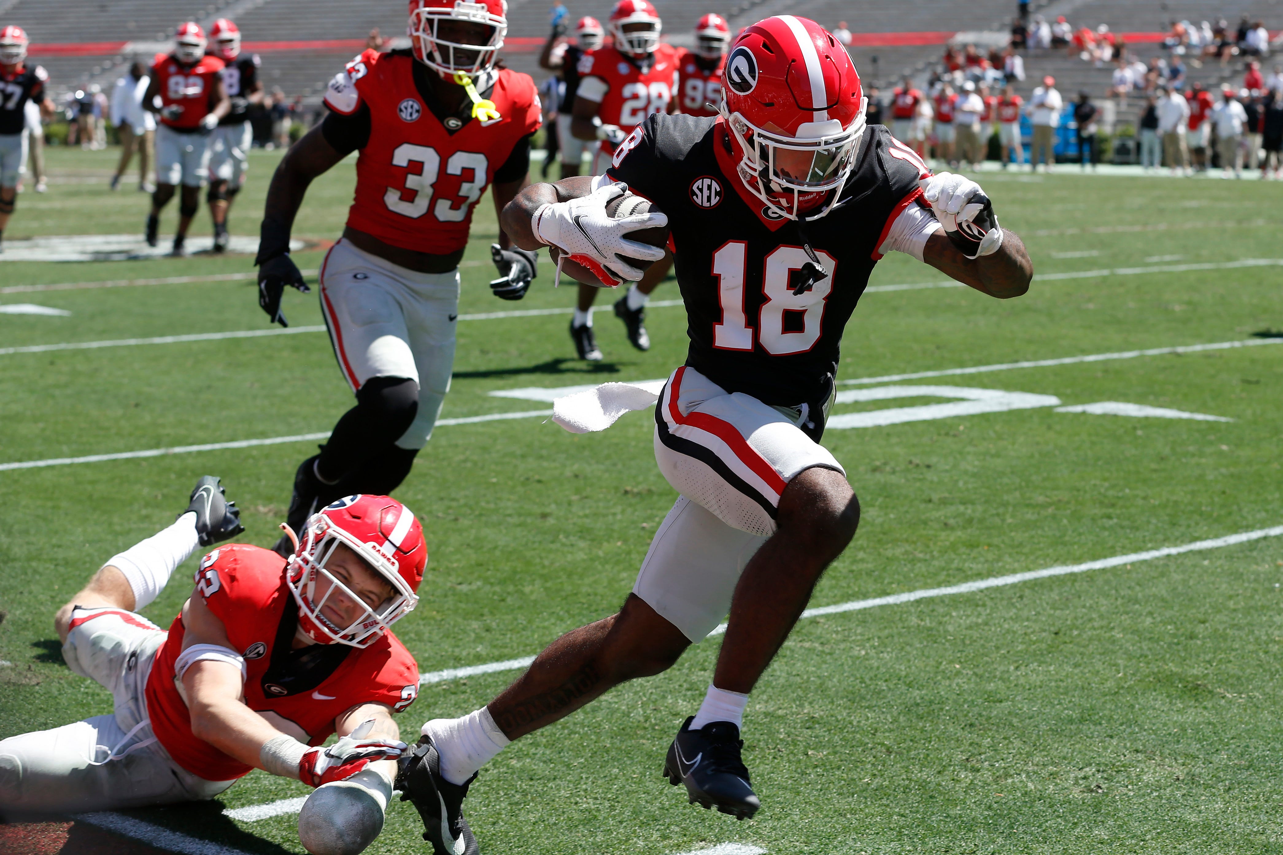 Georgia wide receiver Sacovie White (18) breaks away for a touchdown while Georgia defensive back Jake Pope (22) pulls off White's shoe during the G-Day spring football game in Athens.