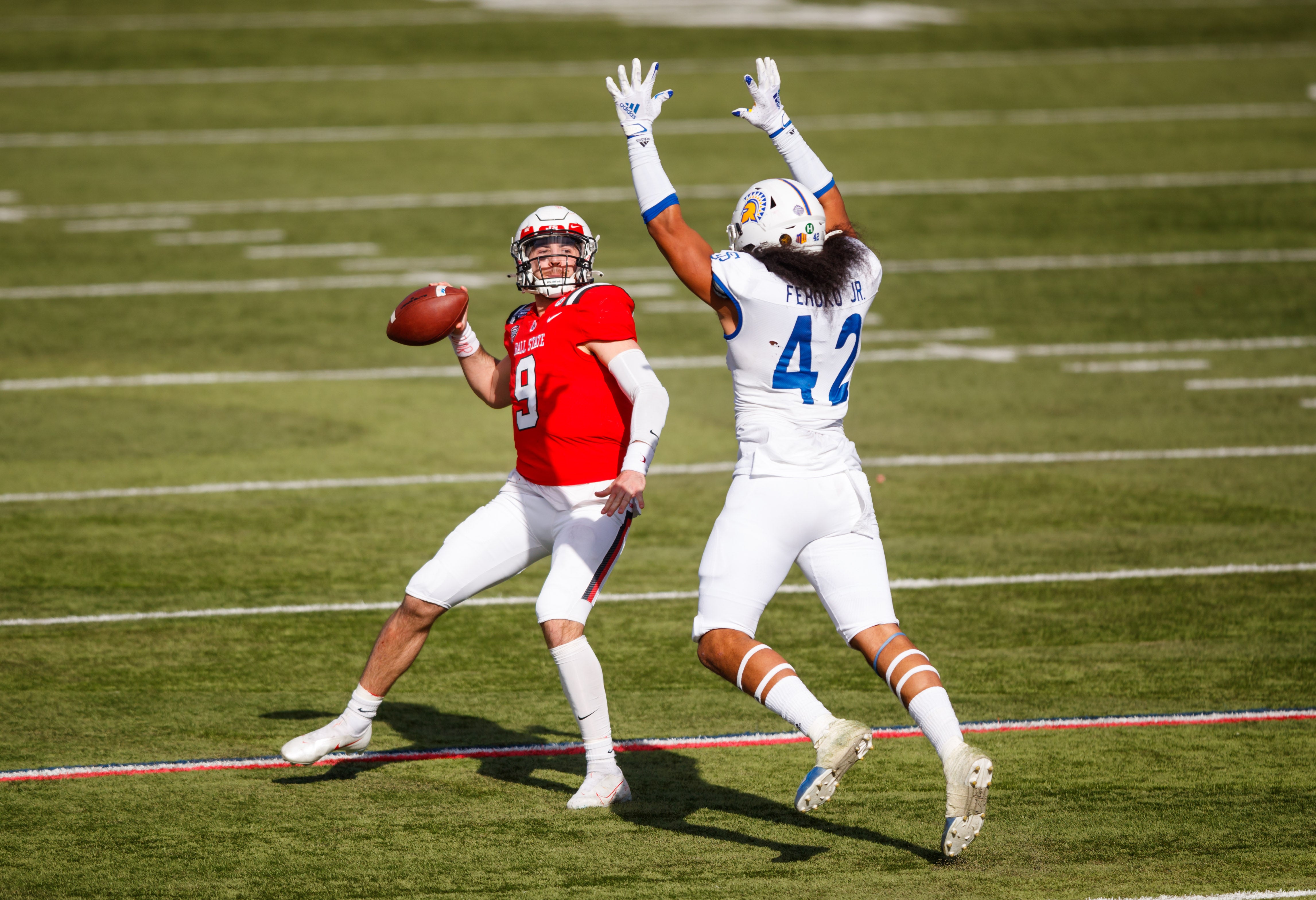 Ball State Cardinals quarterback Drew Plitt (9) throws an interception under pressure from San Jose State Spartans defensive end Viliami Fehoko (42) in the first half of the Arizona Bowl at Arizona Stadium.