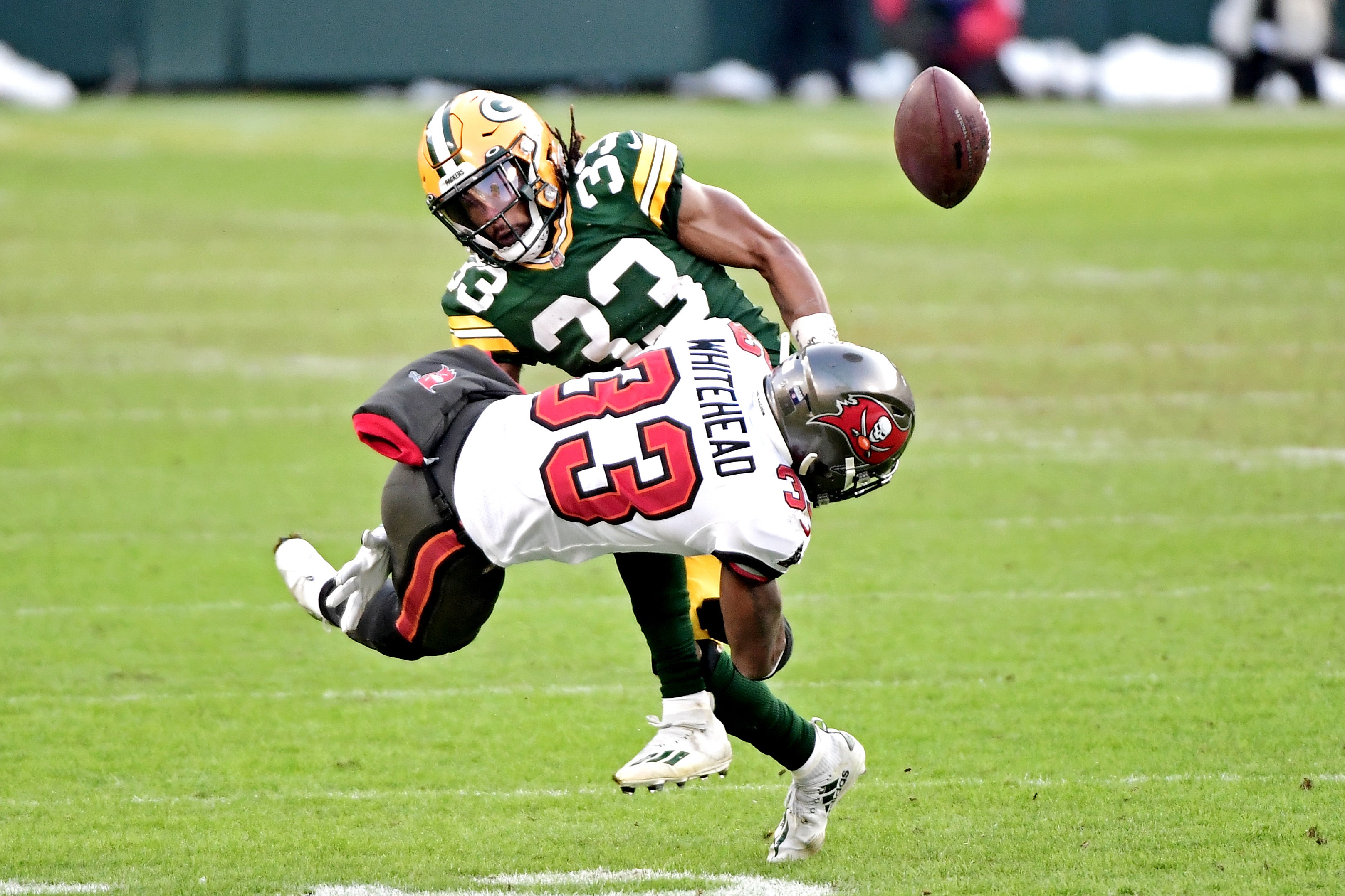 Jan 24, 2021; Green Bay, Wisconsin, USA; Tampa Bay Buccaneers free safety Jordan Whitehead (33) forces a fumble by Green Bay Packers running back Aaron Jones (33) during the third quarter in the NFC Championship Game at Lambeau Field .