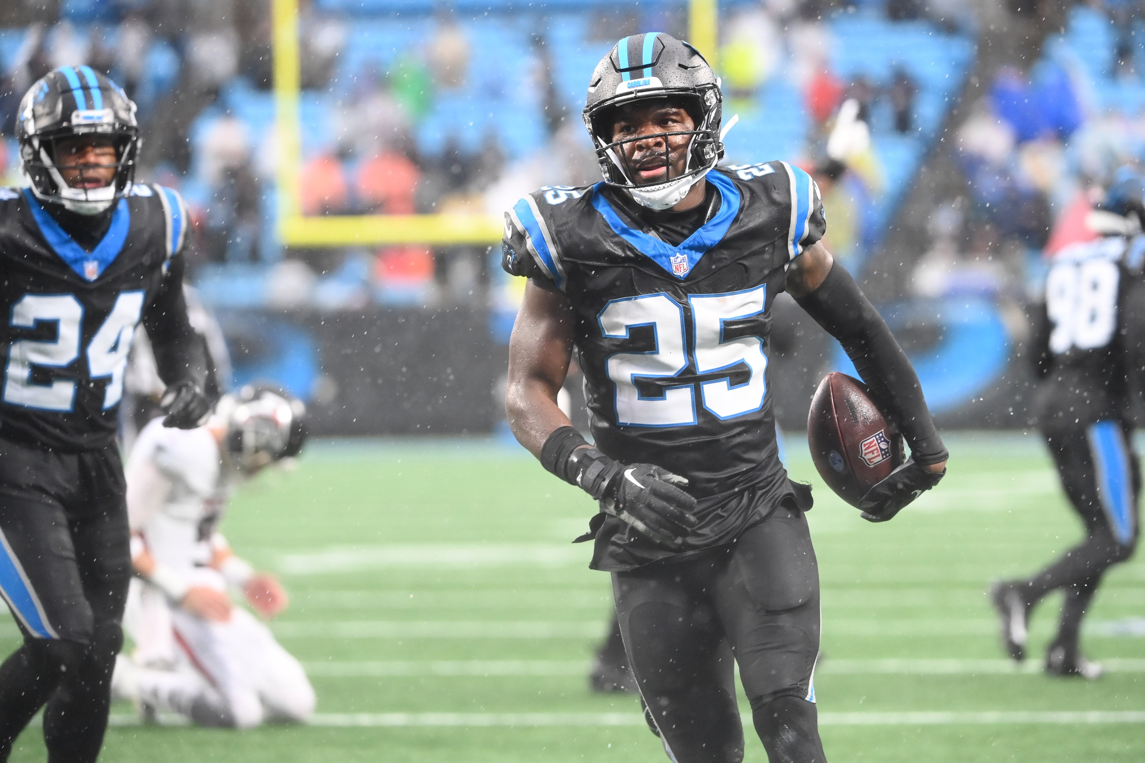 Dec 17, 2023; Charlotte, North Carolina, USA; Carolina Panthers safety Xavier Woods (25) after intercepting the ball as Atlanta Falcons quarterback Desmond Ridder (9) is in the background in the fourth quarter at Bank of America Stadium. Mandatory Credit: Bob Donnan-USA TODAY Sports