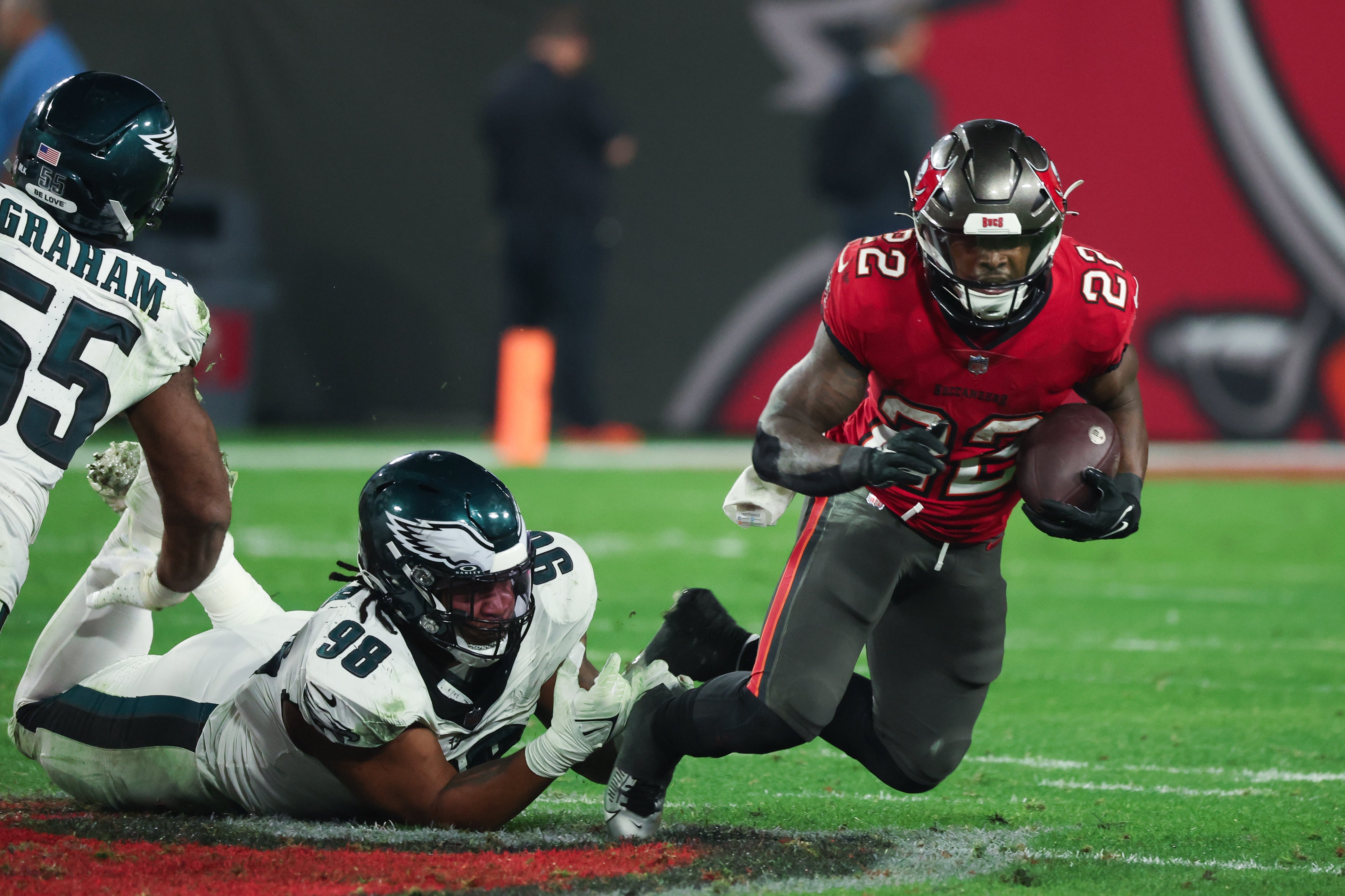 Tampa Bay Buccaneers running back Chase Edmonds (22) is tackled by Philadelphia Eagles defensive tackle Jalen Carter (98) during the second half of a 2024 NFC wild card game at Raymond James Stadium.