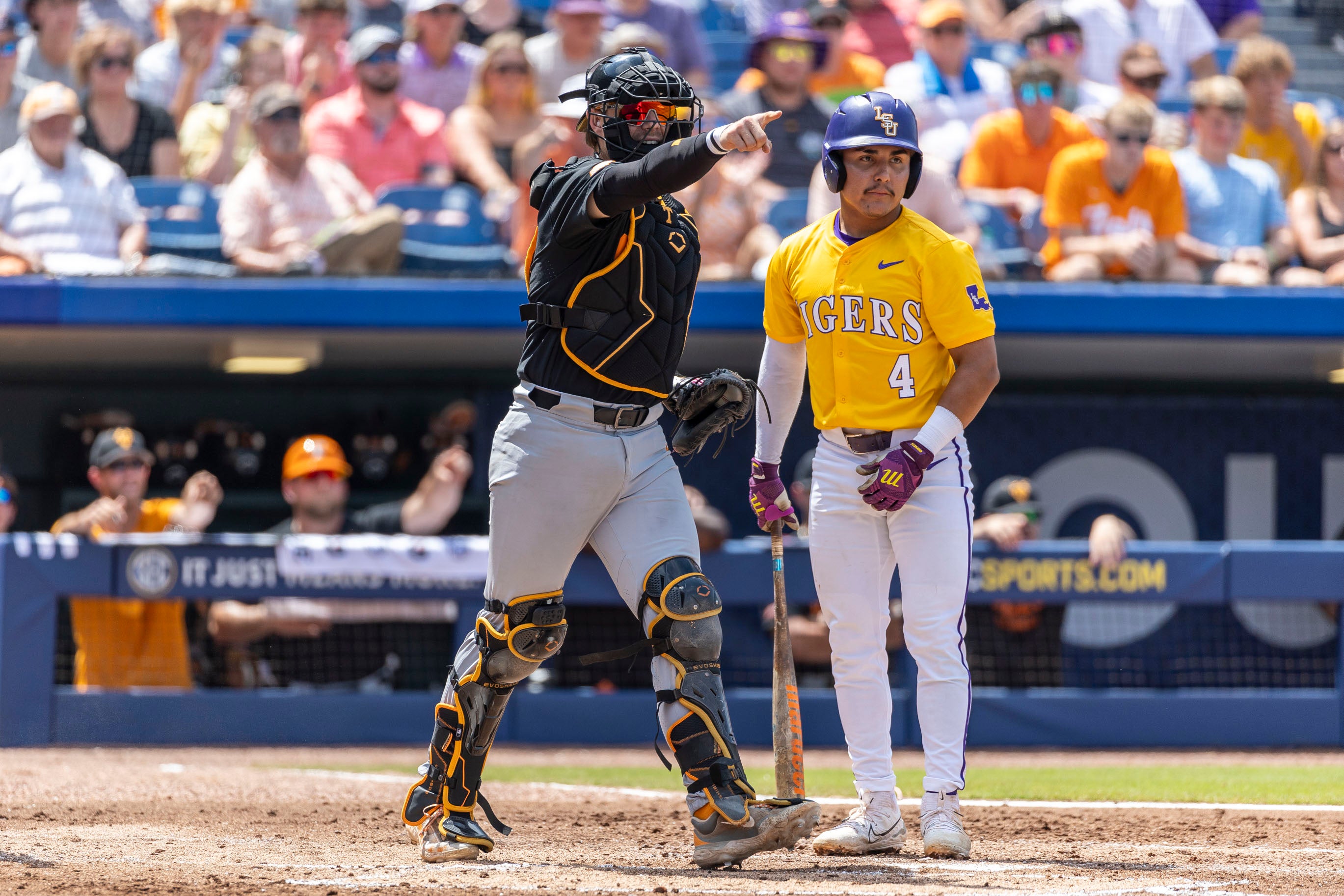 May 26, 2024; Hoover, AL, USA; Tennessee Volunteers catcher Cal Stark (10) signals an appeal at first base as LSU Tigers infielder Steven Milam (4) looks on during the championship game between Tennessee and LSU at the SEC Baseball Tournament at Hoover Metropolitan Stadium.
