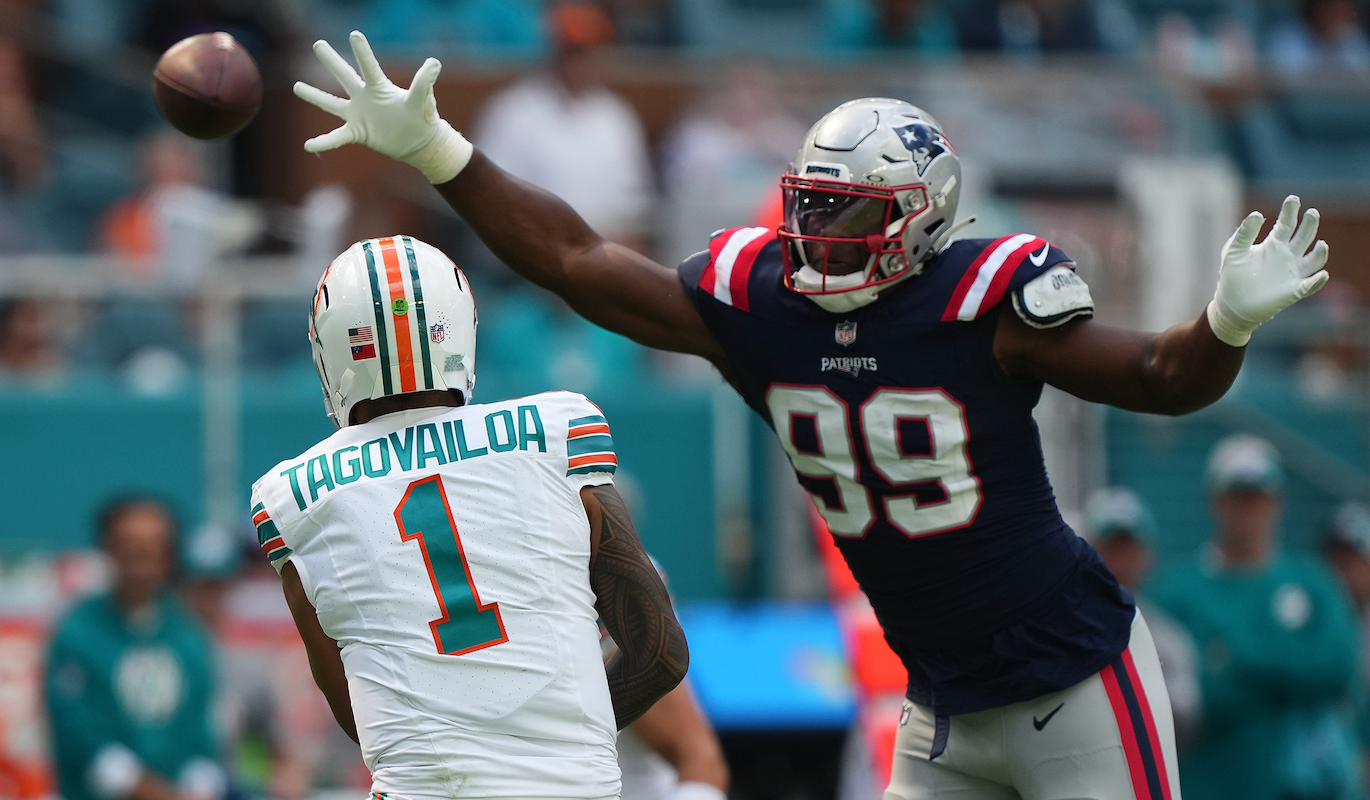Oct 29, 2023; Miami Gardens, Florida, USA; New England Patriots defensive end Keion White (99) reaches for the pass of Miami Dolphins quarterback Tua Tagovailoa (1) during the first half at Hard Rock Stadium.