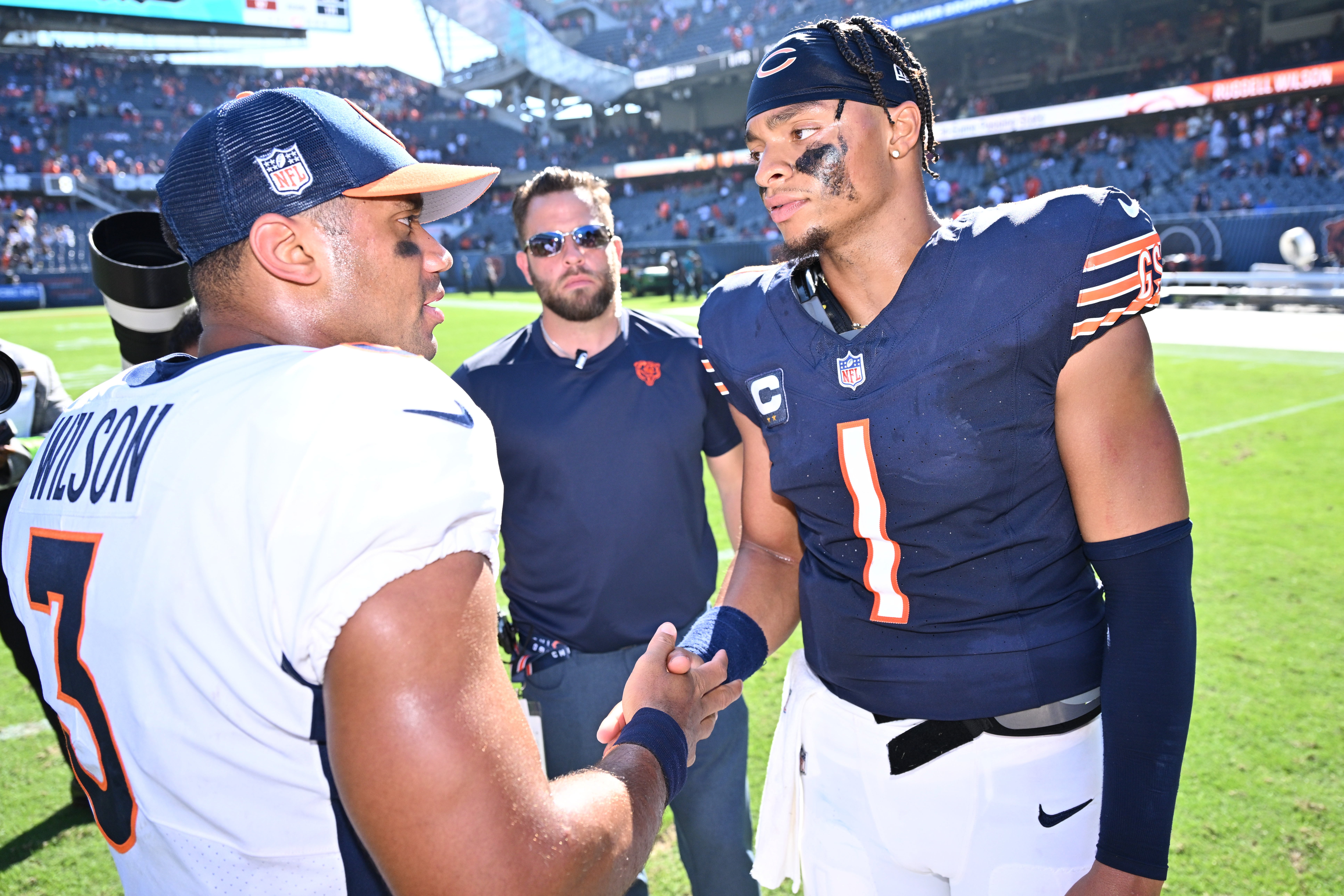 Oct 1, 2023; Chicago, Illinois, USA; Chicago Bears quarterback Justin Fields (1), right, meets with Denver Broncos quarterback Russell Wilson (3) at midfield after their game at Soldier Field. Mandatory Credit: Jamie Sabau-USA TODAY Sports
