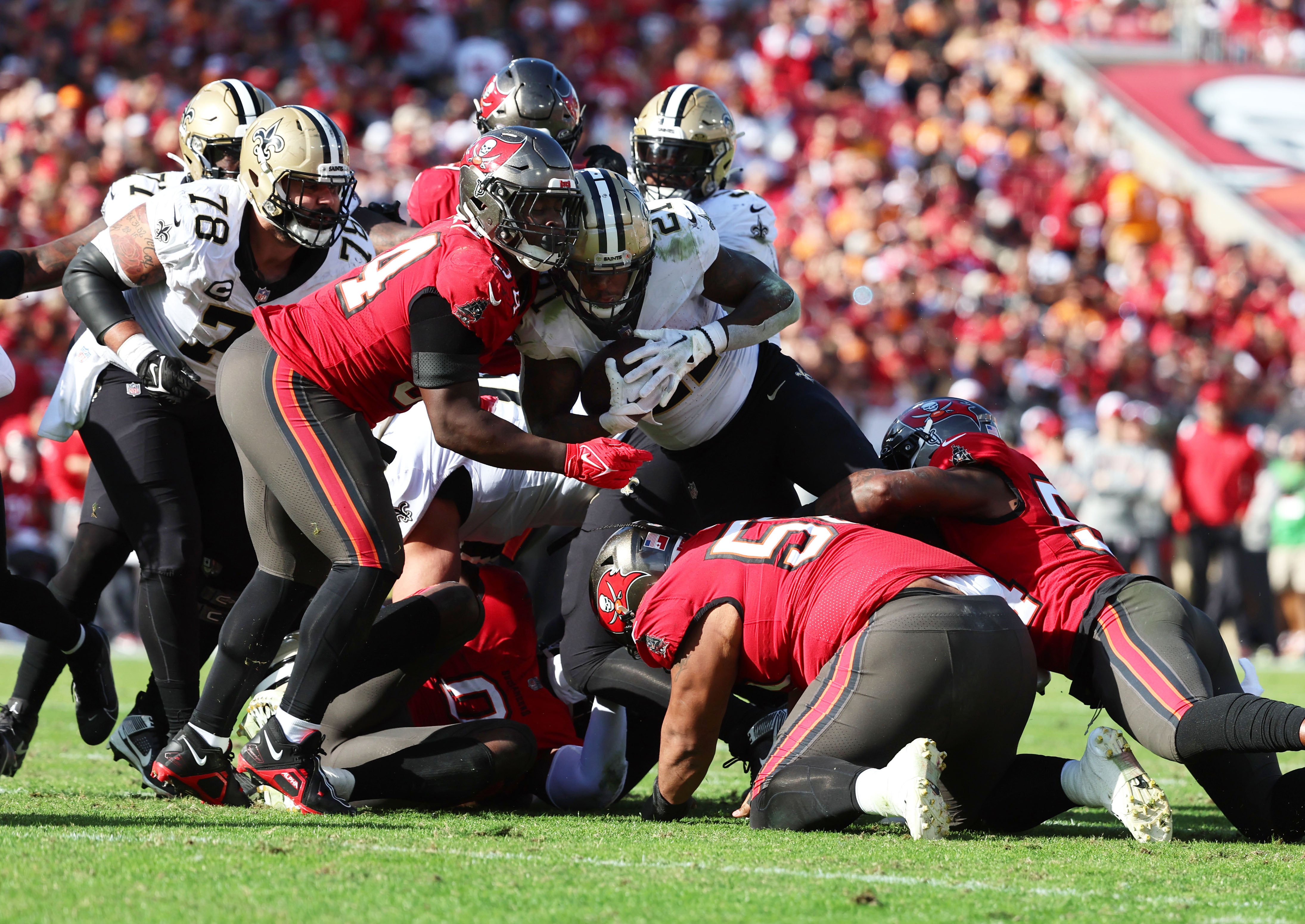 Dec 31, 2023; Tampa, Florida, USA; New Orleans Saints running back Jamaal Williams (21) runs with the ball as Tampa Bay Buccaneers linebacker Lavonte David (54) defends during the second half at Raymond James Stadium.