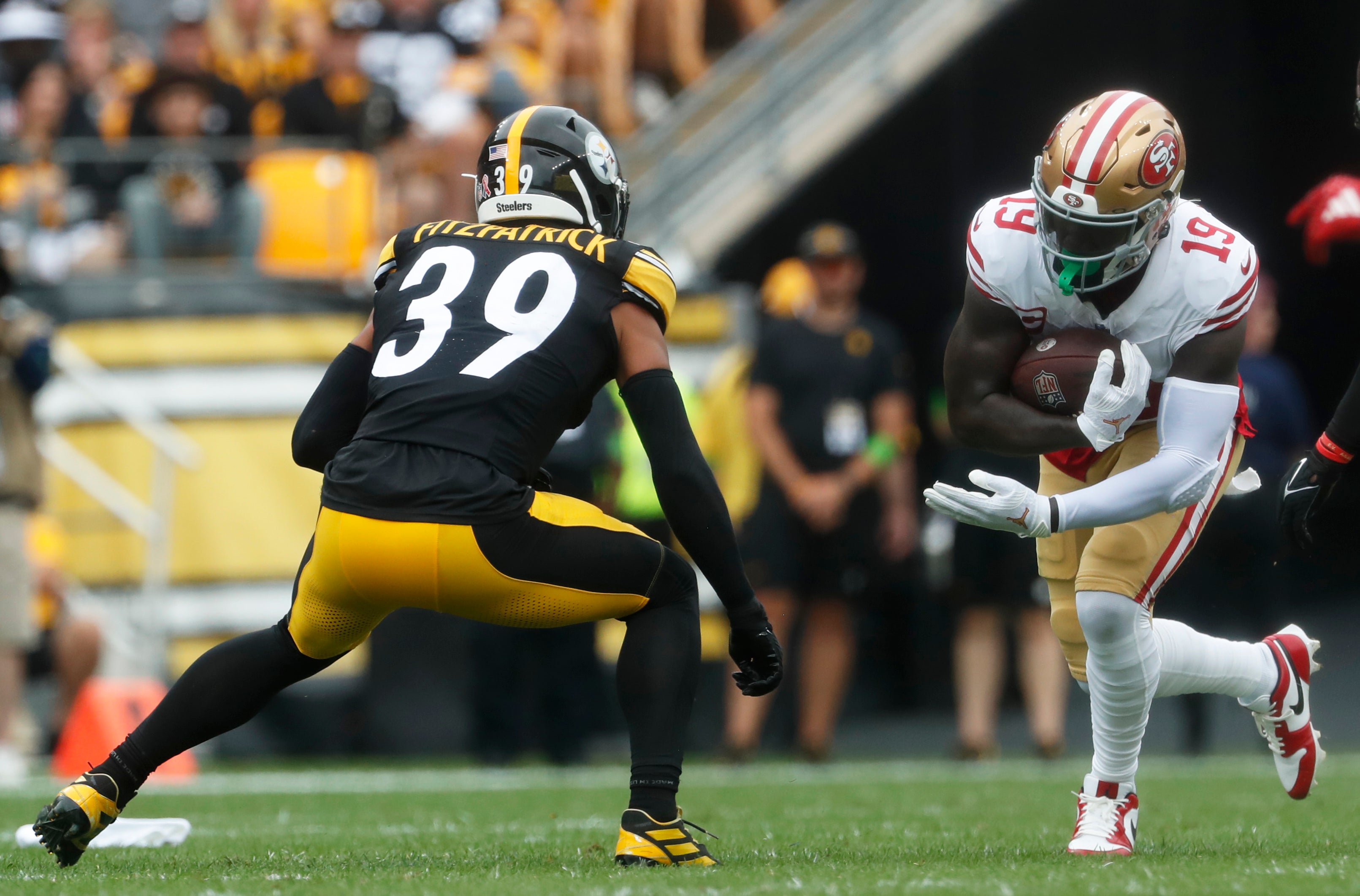 49ers wide receiver Deebo Samuel runs after a catch as Steelers safety Minkah Fitzpatrick defends.