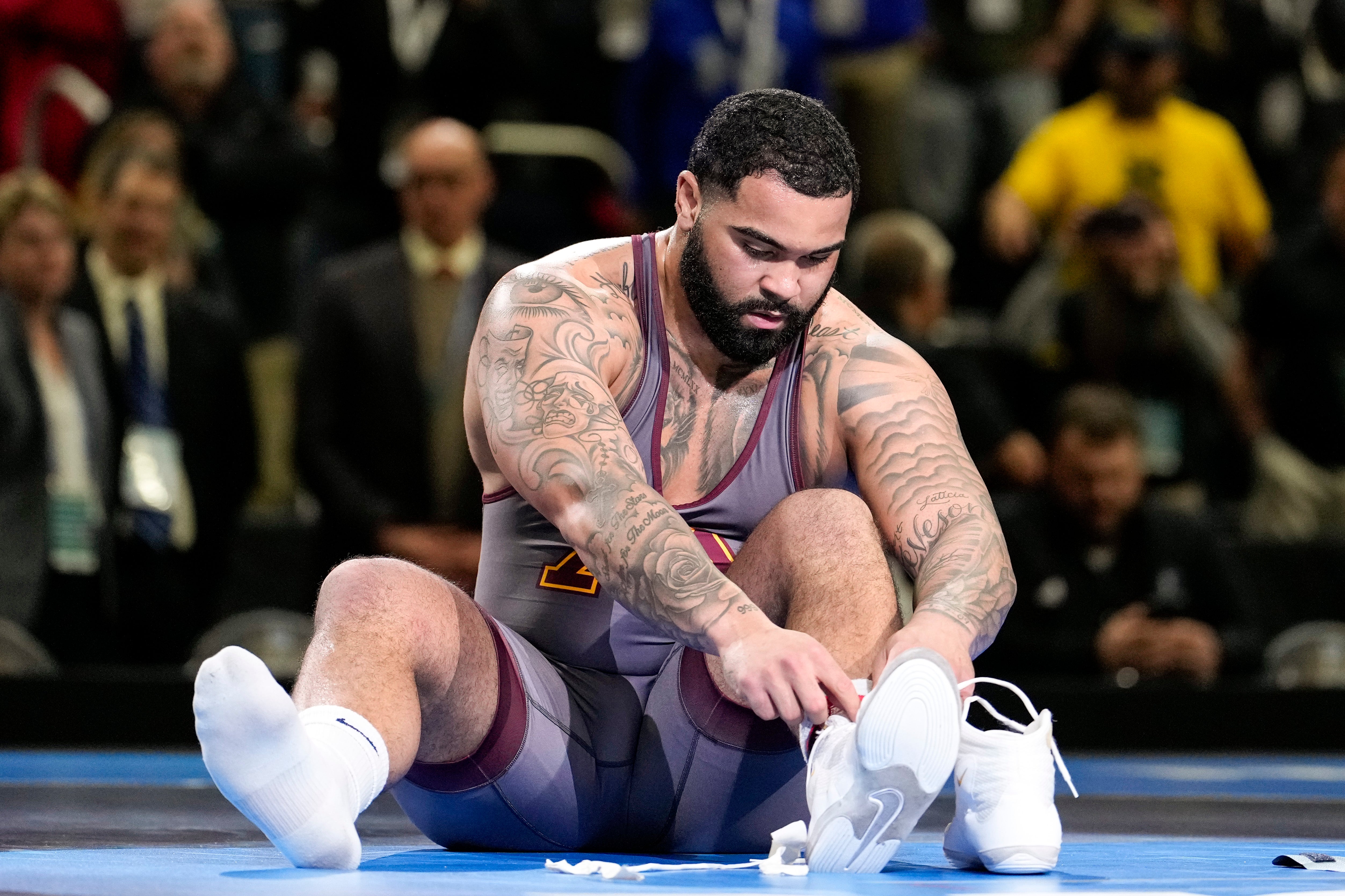 Mar 19, 2022; Detroit, MI, USA; Minnesota wrestler Gable Steveson takes his shoes off on the mat after defeating Arizona State wrestler Cohlton Schultz (not pictured) in the 285 pound weight class final match during the NCAA Wrestling Championships at Little Cesars Arena