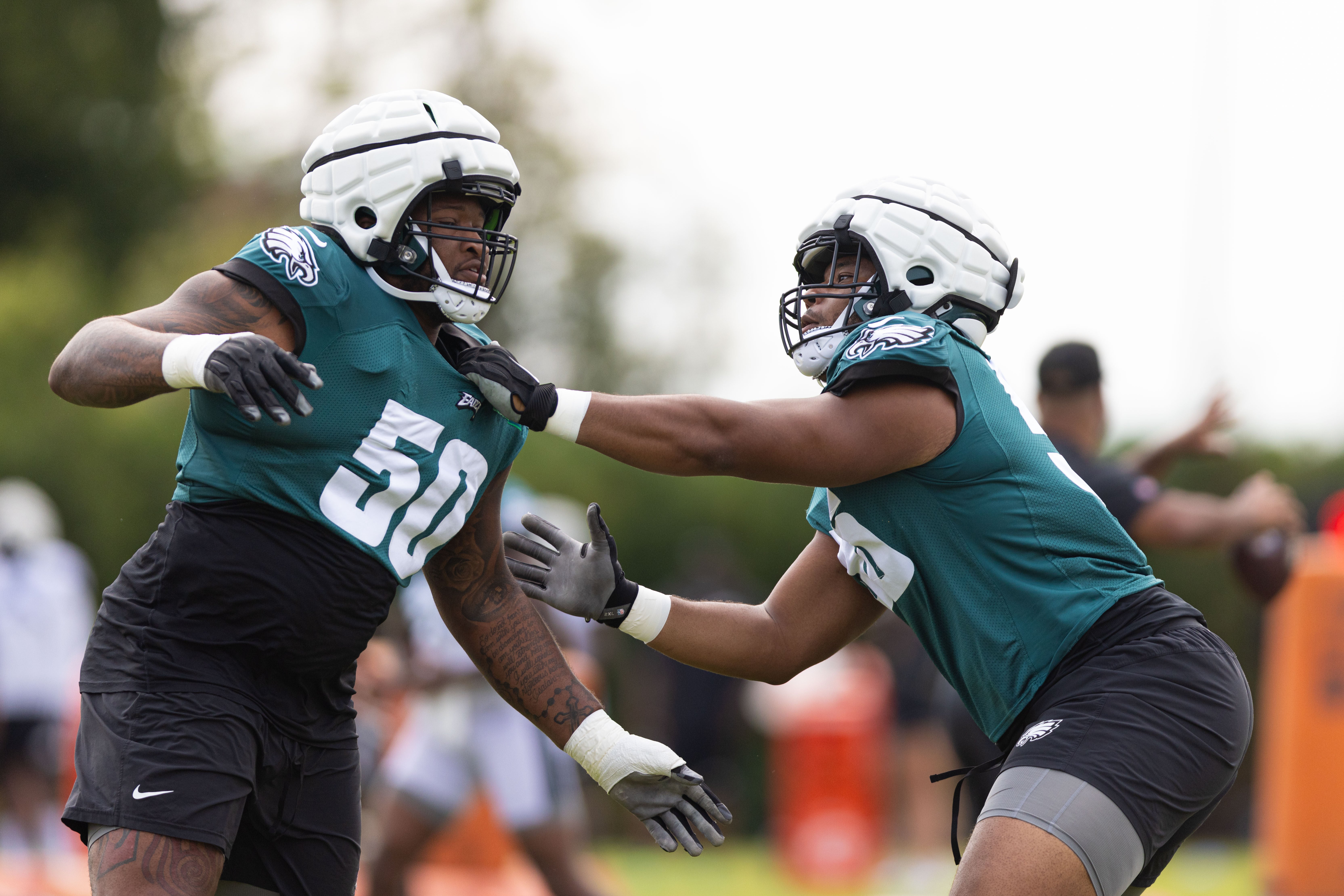 Philadelphia Eagles guard Tyler Steen (R) and offensive tackle Fred Johnson (50) run drills during practice at Novacare Complex.