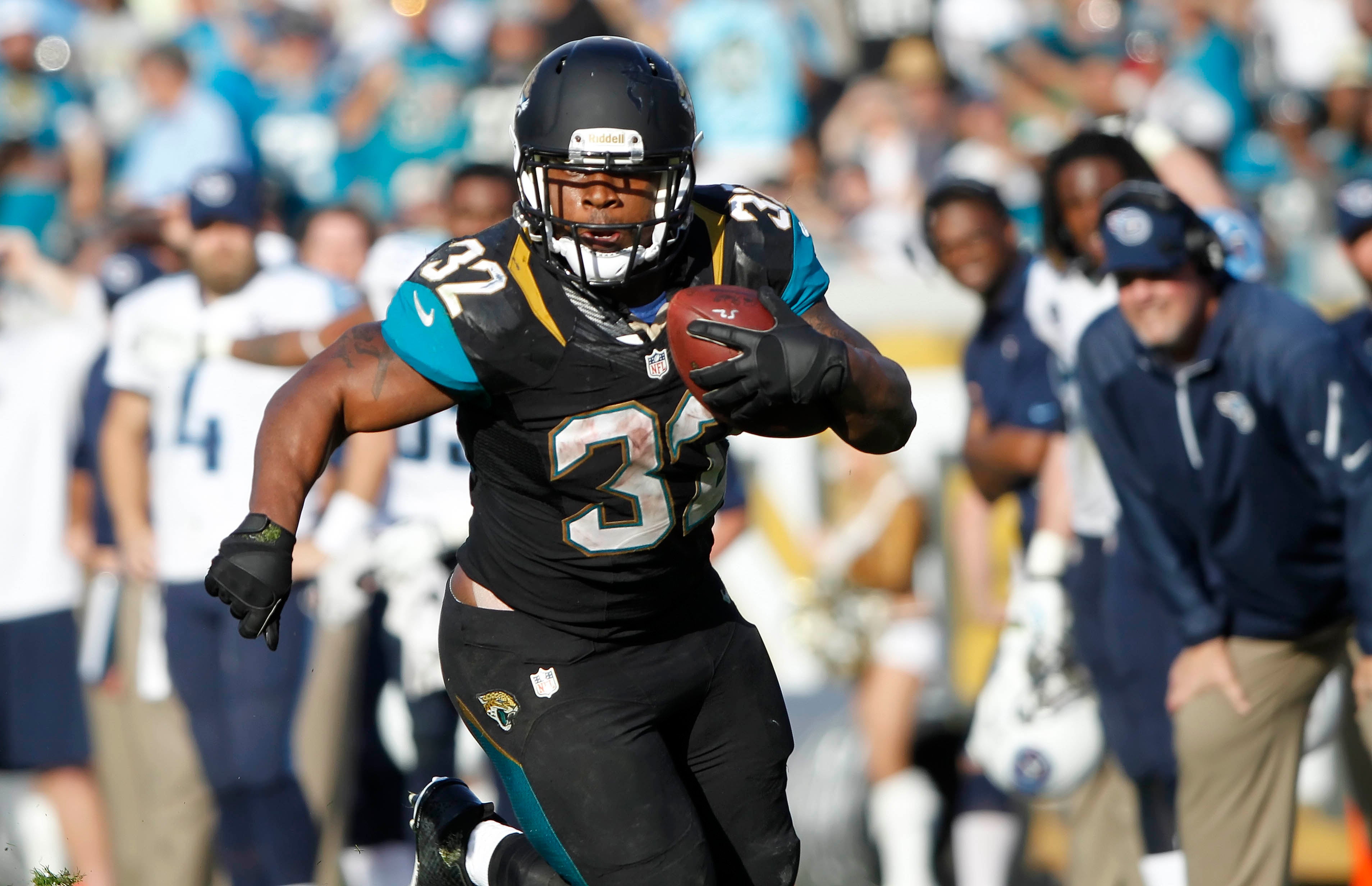 Dec 22, 2013; Jacksonville, FL, USA; Jacksonville Jaguars running back Maurice Jones-Drew (32) runs with the ball as Tennessee Titans defends during the second half at EverBank Field. Tennessee Titans defeated the Jacksonville Jaguars 20-16.