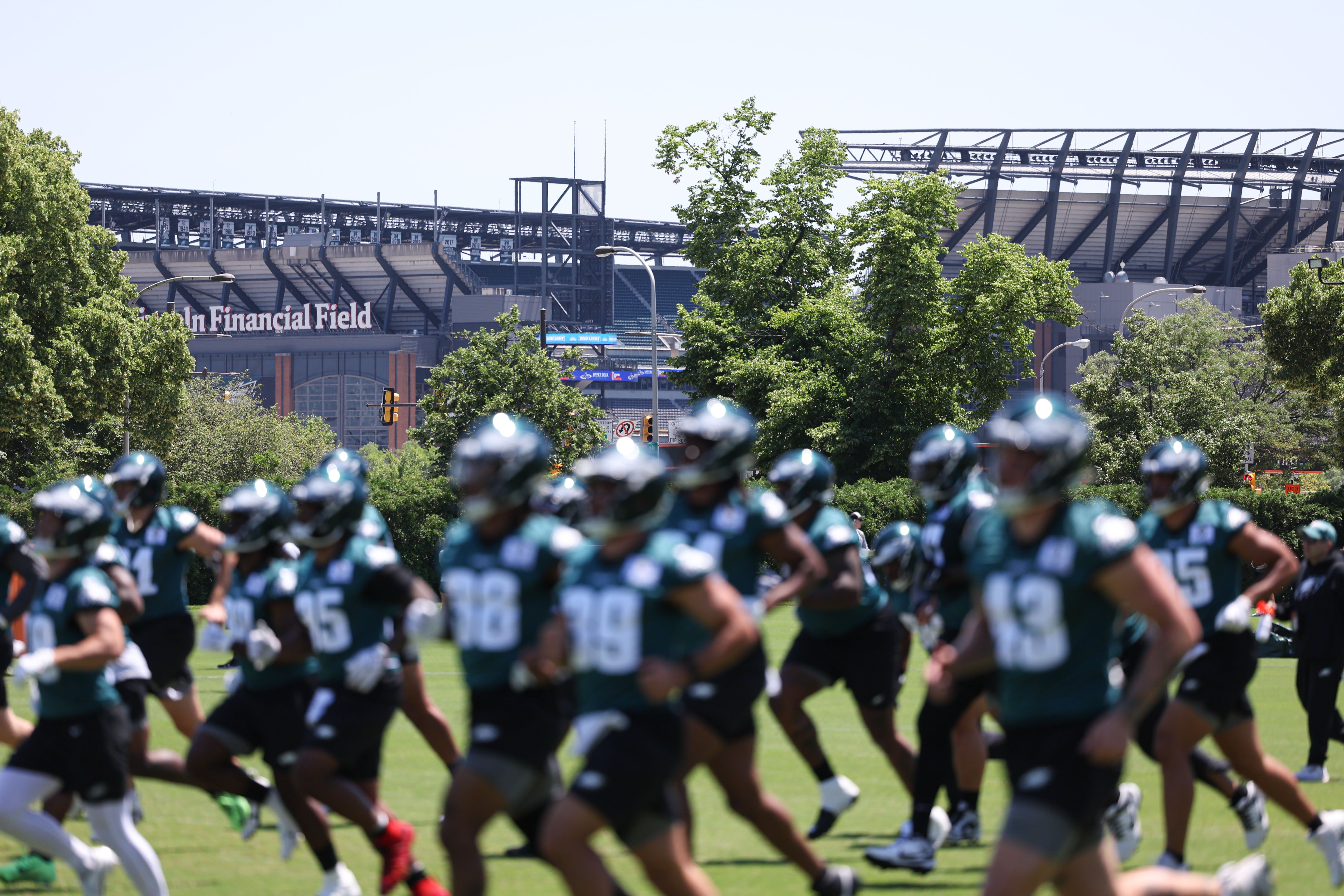 Lincoln Financial Field can be seen behind the Philadelphia Eagles as they run drills at NovaCare Complex.