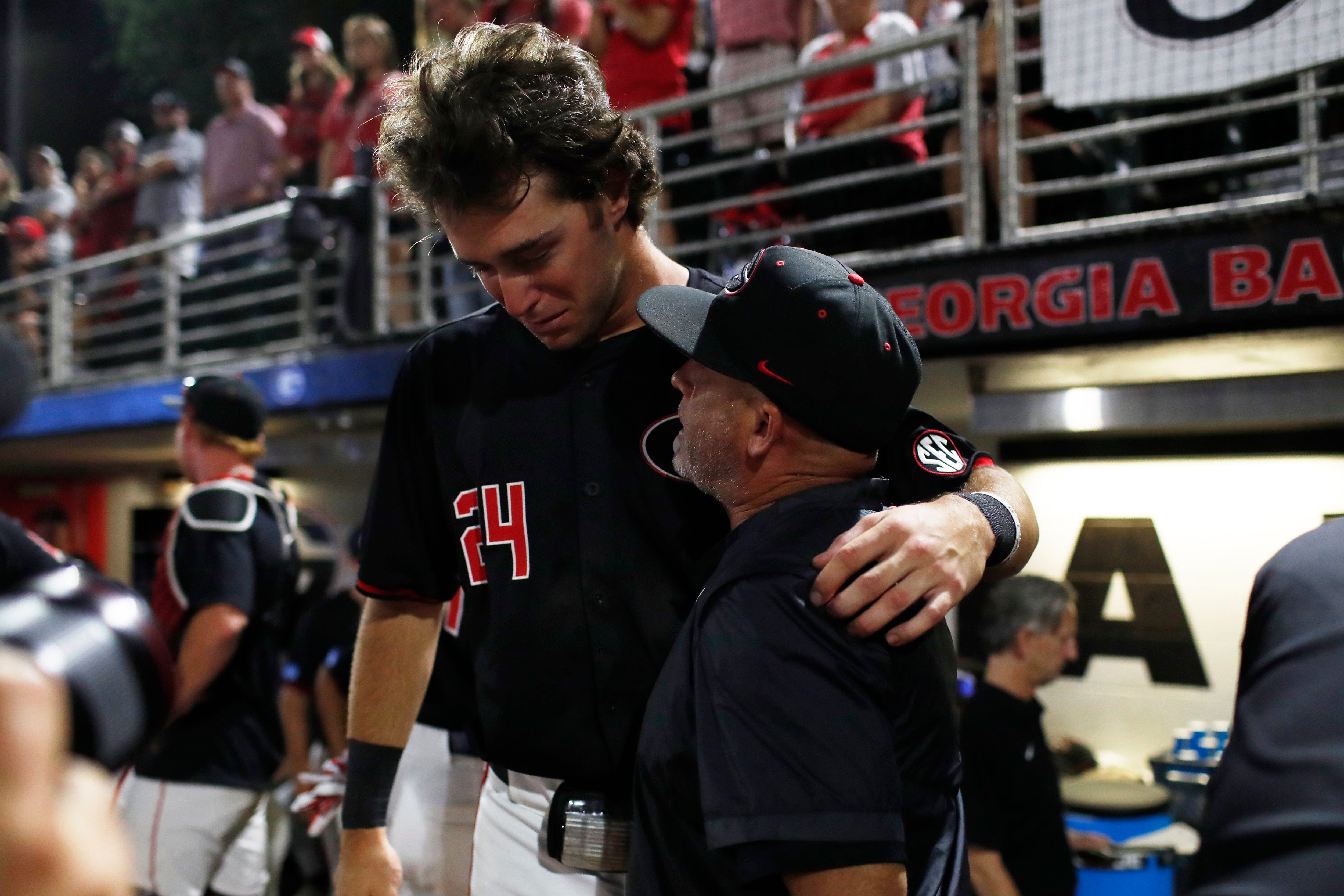 Georgia coach Wes Johnson consoles Georgia's Charlie Condon (24) after losing Game 3 of the Super NCAA Regional against NC State at Foley Field on Monday, June 10, 2024 in Athens, Ga. NC State won 8-5.
