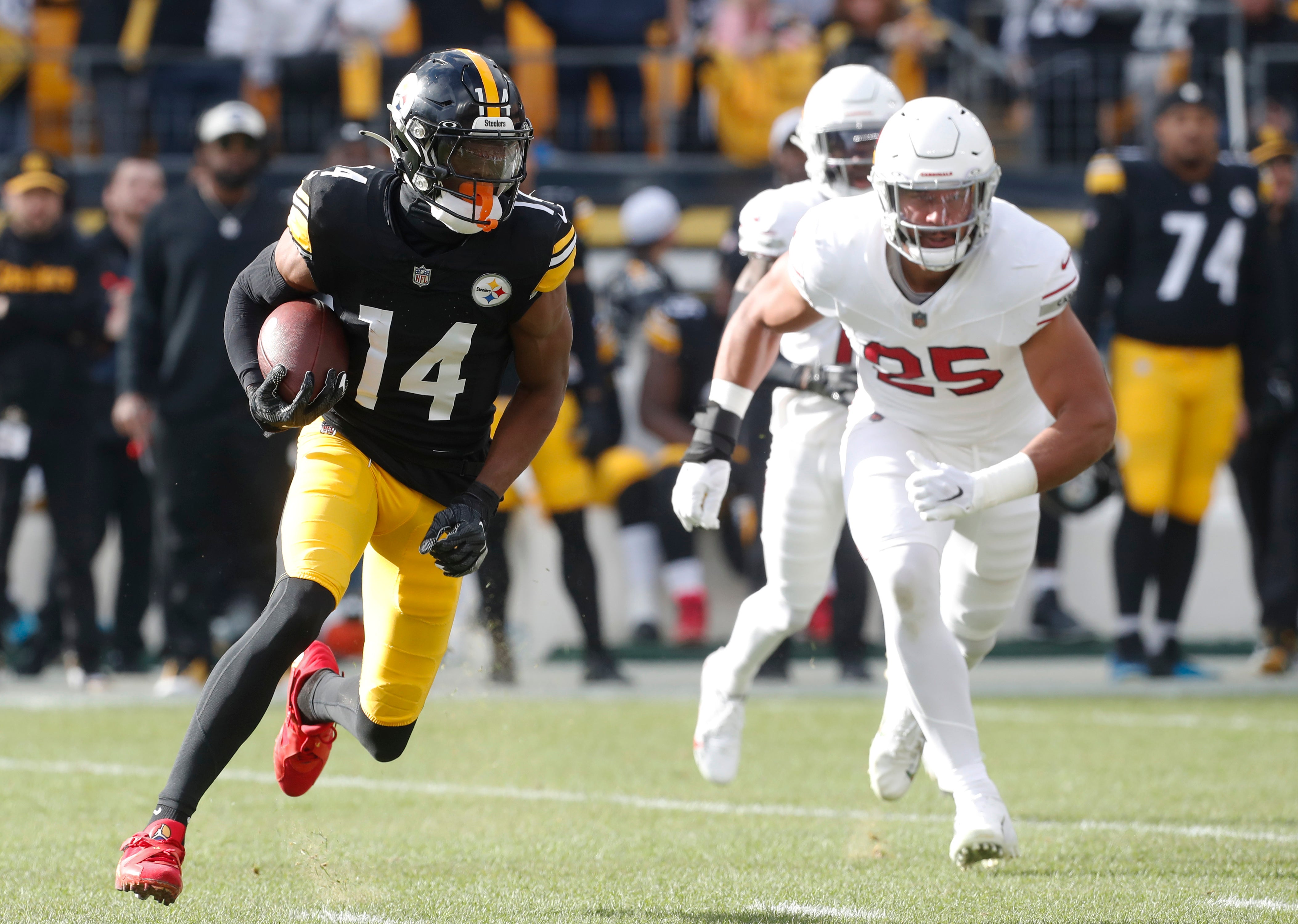 Dec 3, 2023; Pittsburgh, Pennsylvania, USA; Pittsburgh Steelers wide receiver George Pickens (14) runs after a catch as Arizona Cardinals linebacker Zaven Collins (25) chases during the first quarter at Acrisure Stadium. Mandatory Credit: Charles LeClaire-USA TODAY Sports