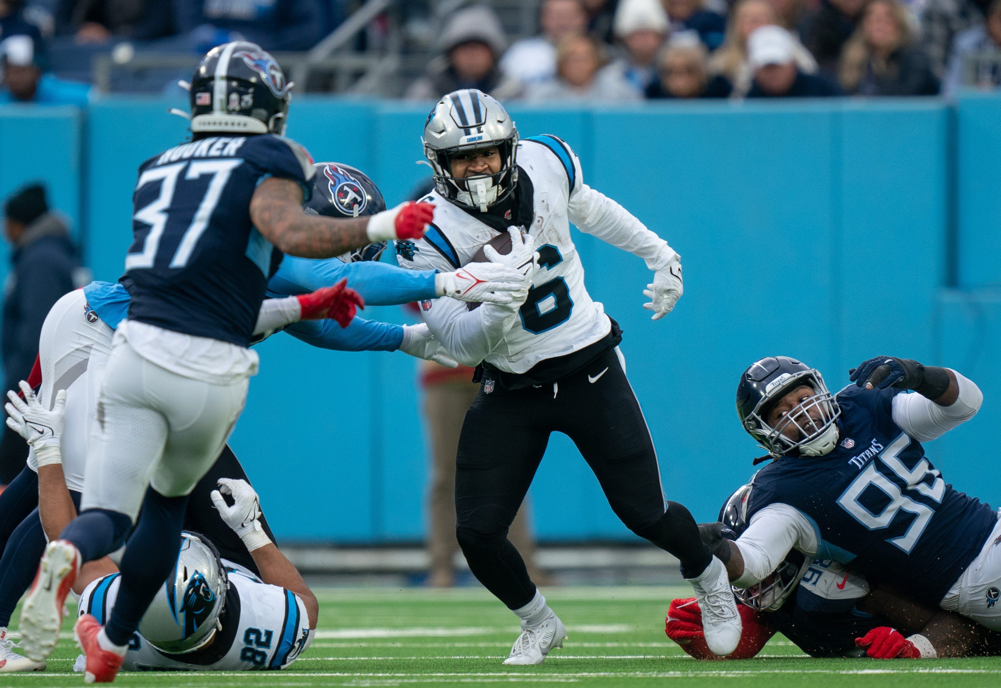 Carolina Panthers running back Miles Sanders (6) eludes the tackle of Tennessee Titans defensive end Denico Autry (96) during their game at Nissan Stadium in Nashville, Tenn., Sunday, Nov. 26, 2023.
