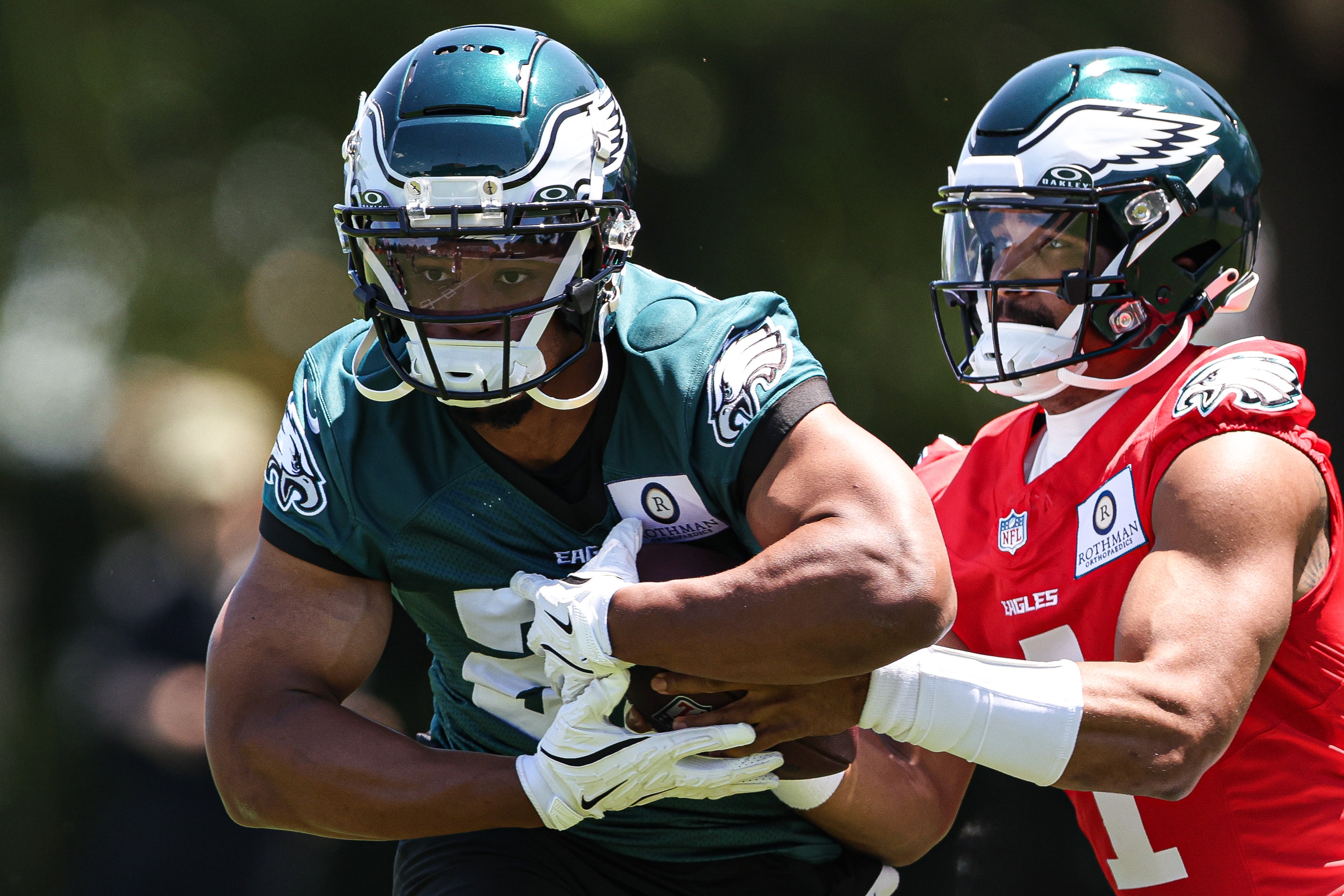 May 30, 2024; Philadelphia, PA, USA; Philadelphia Eagles quarterback Jalen Hurts (1) hands off to running back Saquon Barkley (26) during practice at NovaCare Complex.