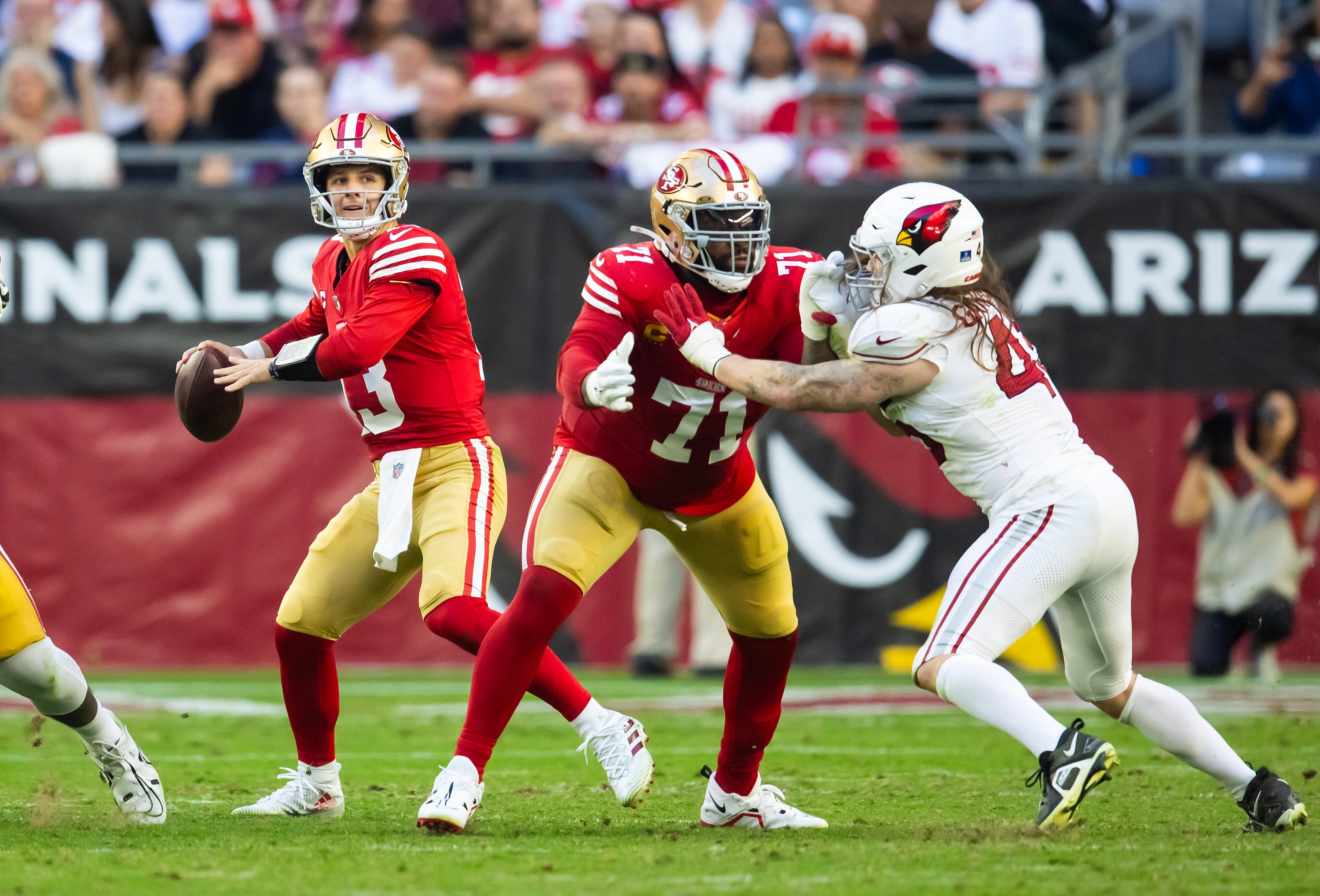 Dec 17, 2023; Glendale, Arizona, USA; San Francisco 49ers offensive lineman Trent Williams (71) blocks for quarterback Brock Purdy (13) against Arizona Cardinals linebacker Dennis Gardeck (45) at State Farm Stadium.