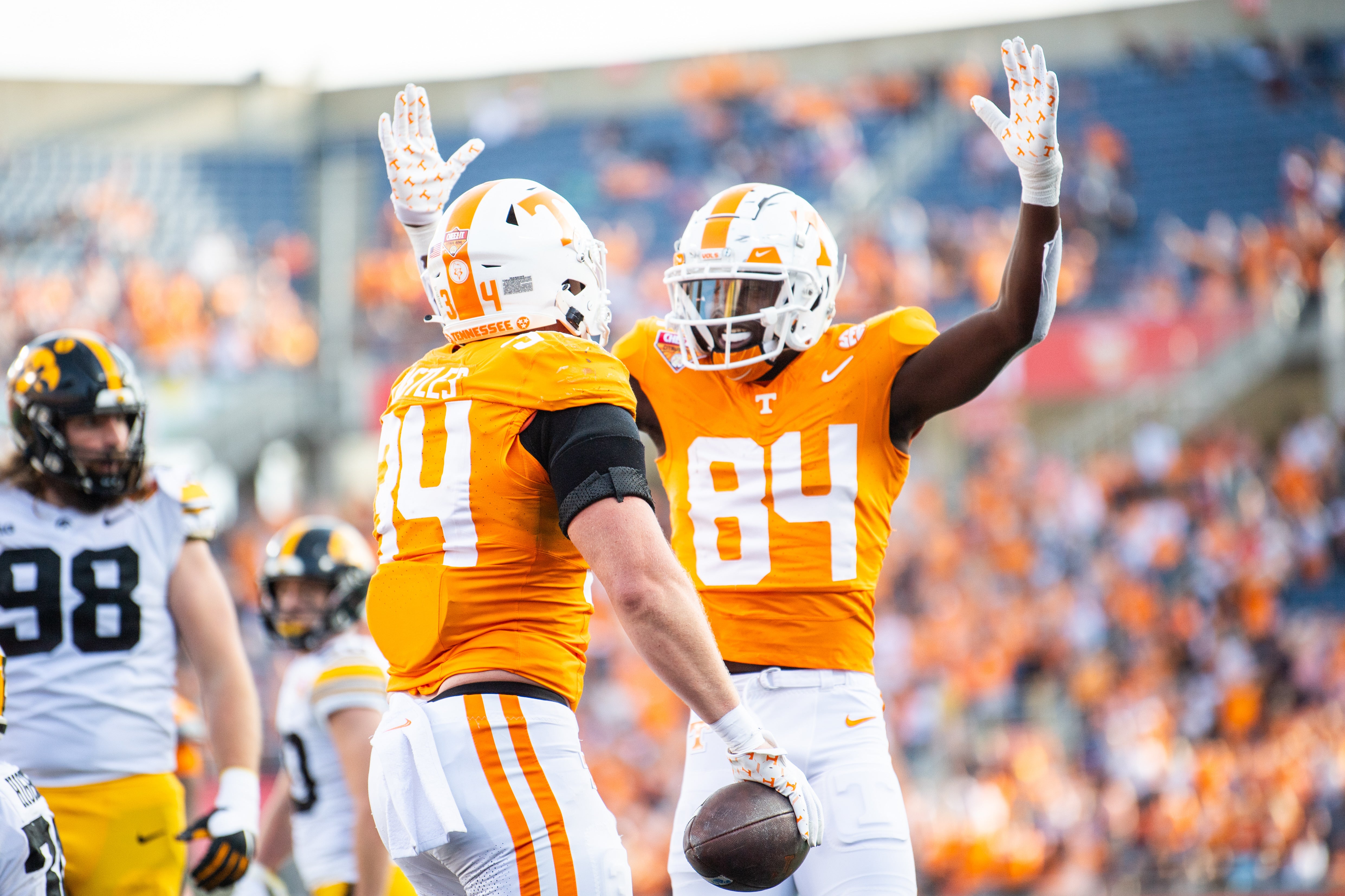 Jan 1, 2024; Orlando, FL, USA; Tennessee Volunteers tight end McCallan Castles (34) and wide receiver Kaleb Webb (84) celebrate Castles touchdown against the Iowa Hawkeyes in the fourth quarter at Camping World Stadium.