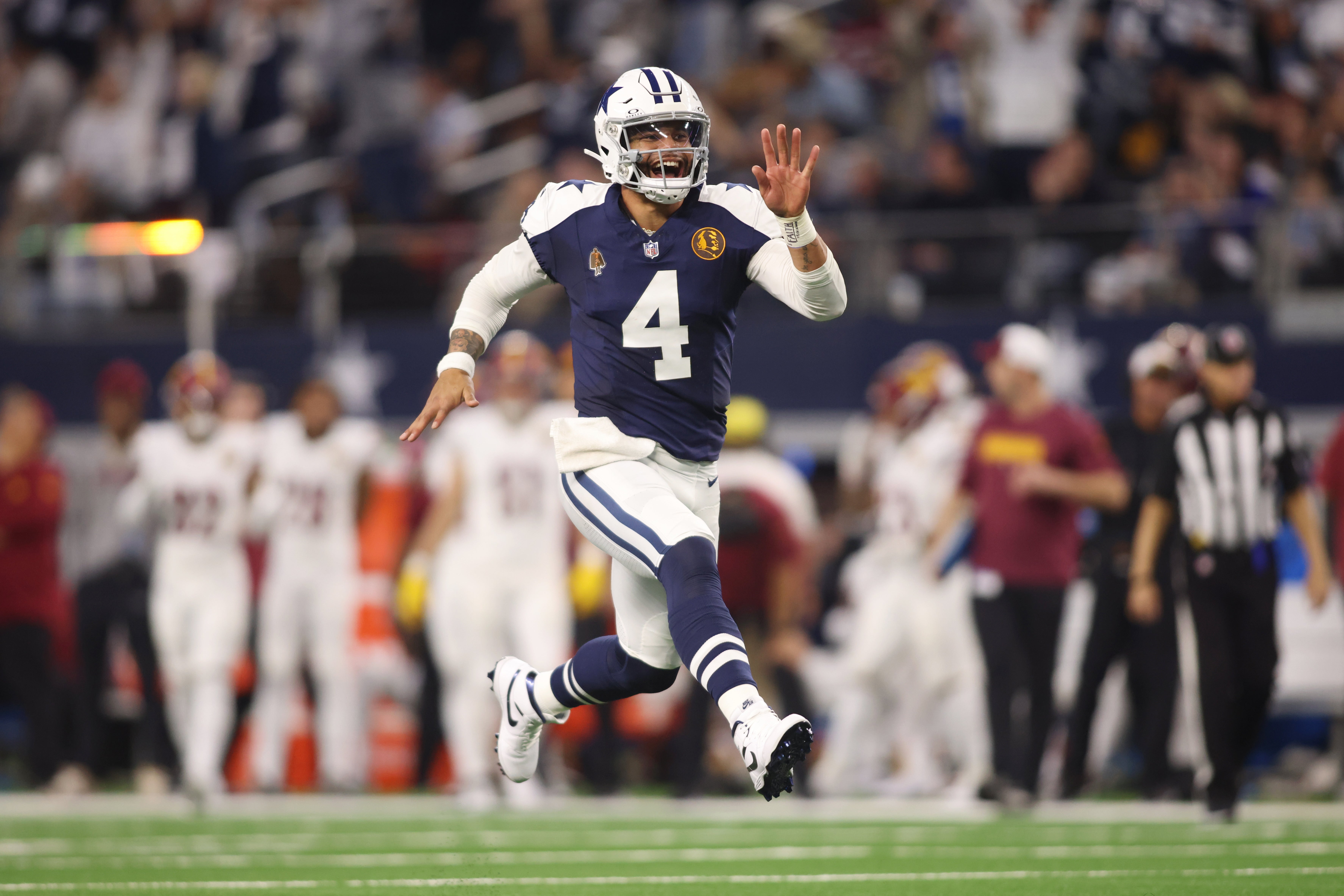 Dallas Cowboys quarterback Dak Prescott (4) celebrates throwing a touchdown in the fourth quarter against the Washington Commanders at AT&T Stadium.