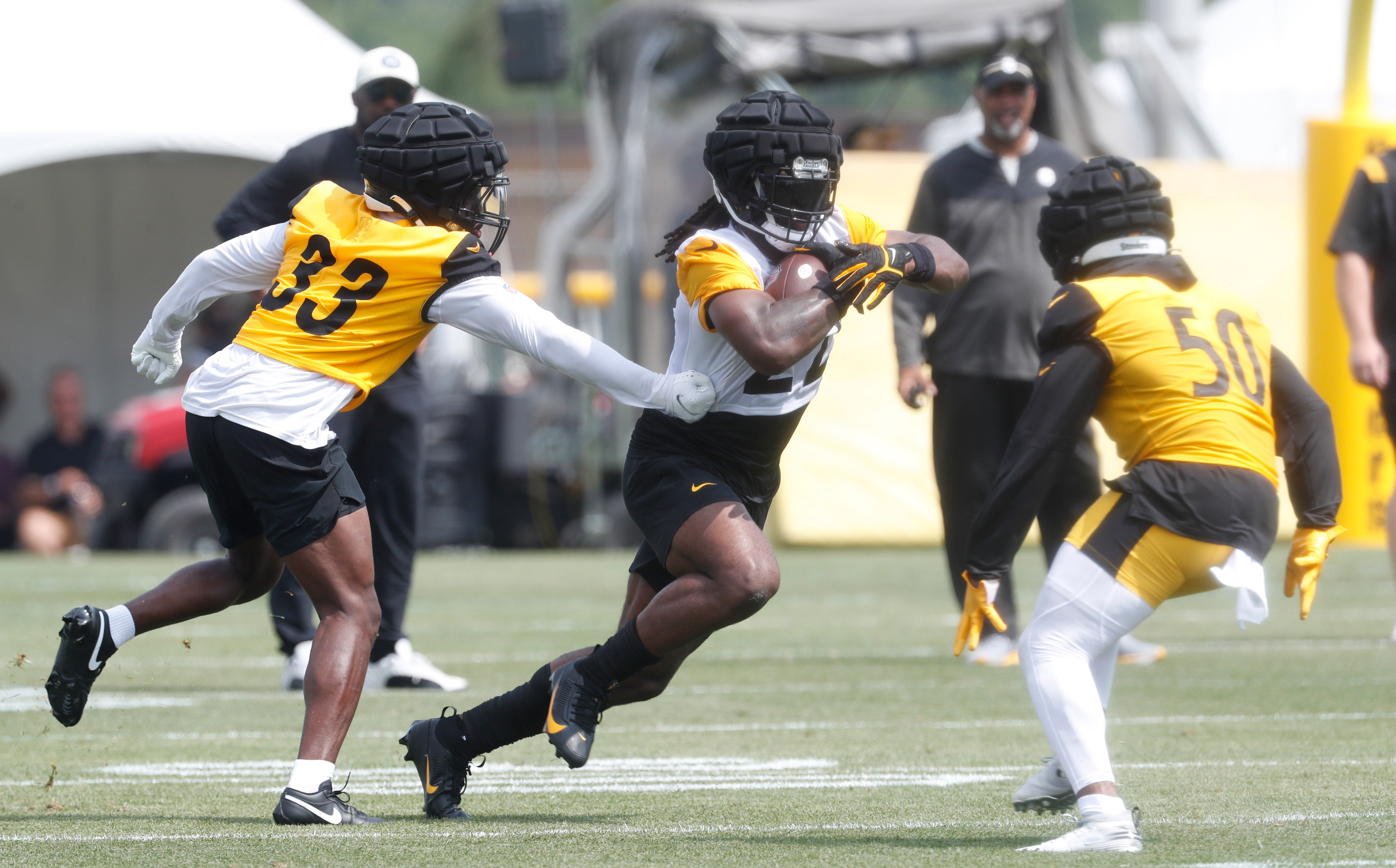 Jul 27, 2023; Latrobe, PA, USA; Pittsburgh Steelers running back Najee Harris (22) runs the ball against cornerback Duke Dawson (33) and linebacker Elandon Roberts (50) in drills during training camp at Saint Vincent College. Mandatory Credit: Charles LeClaire-USA TODAY Sports