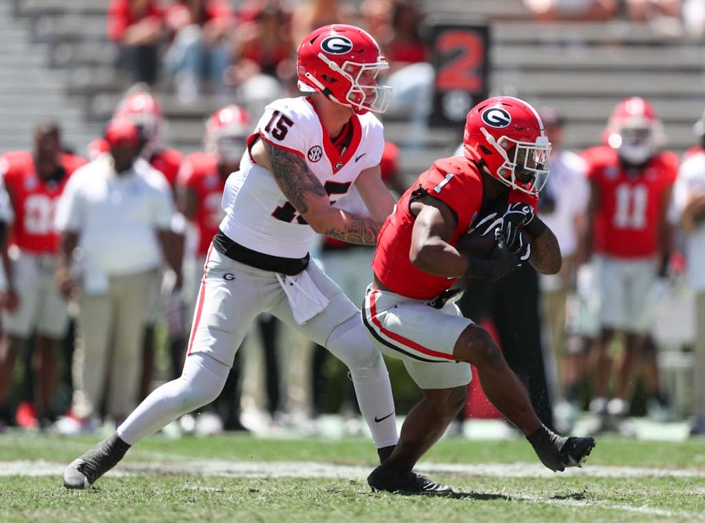 Georgia Bulldogs quarterback Carson Beck (15) hands ball to running back Trevor Etienne (1) during the G-Day Game at Sanford Stadium.