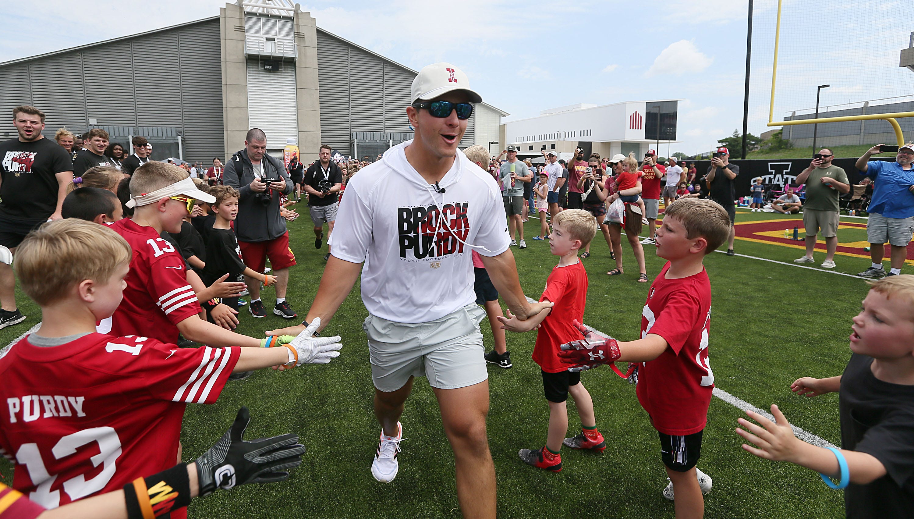 Former Iowa State quarterback and San Francisco 49ers quarterback Brock Purdy high-fives with campers at the Brock Purdy Youth Football camp at Jack Trice Stadium football practice field on Saturday, June 22, 2024, in Ames, Iowa