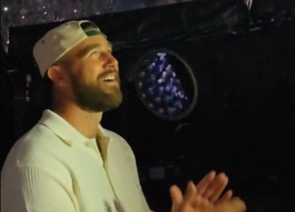 Travis Kelce smiles while watching Taylor Swift perform during the second night of her Eras Tour shows at Wembley Stadium
