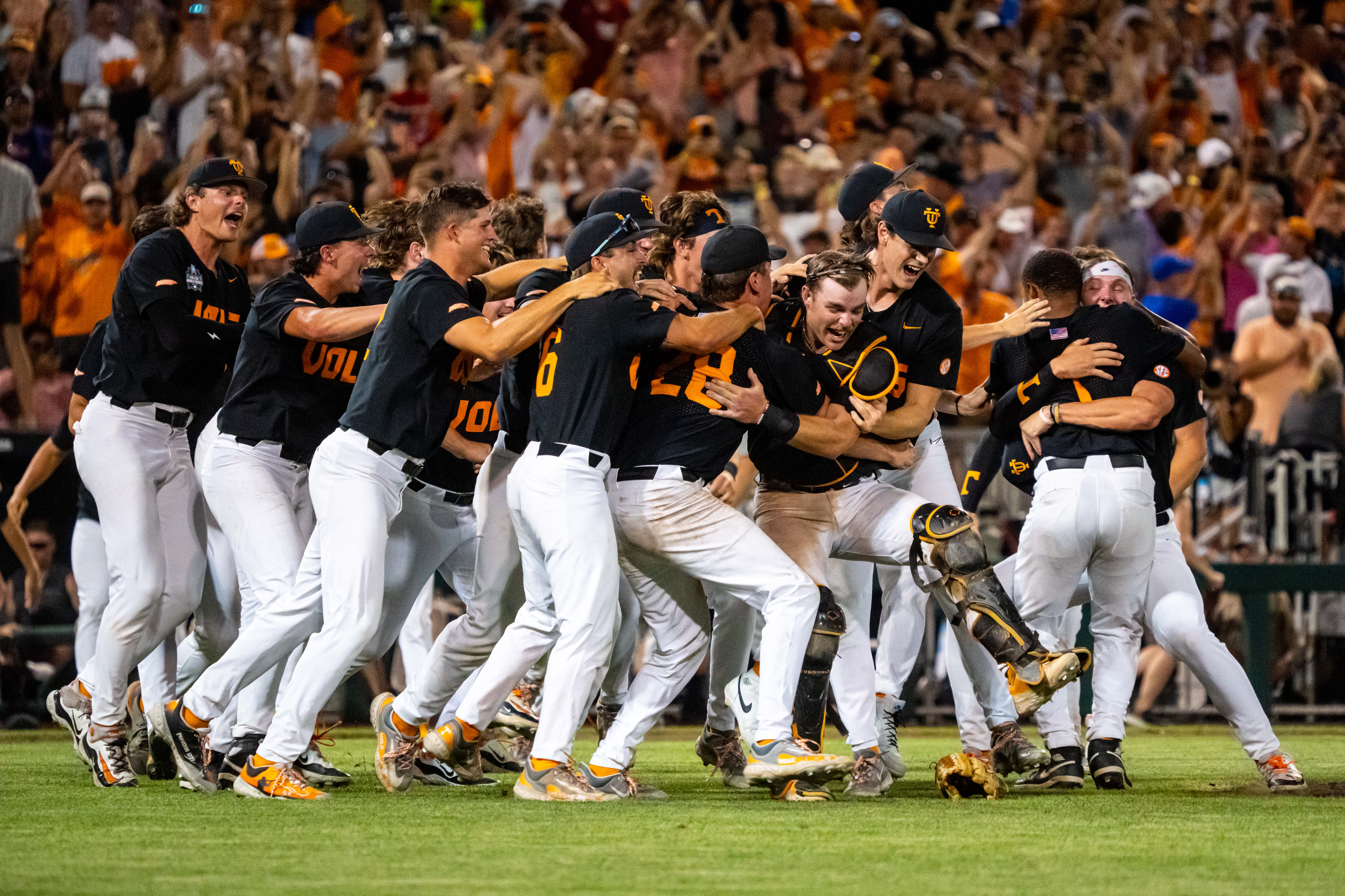 Jun 24, 2024; Omaha, NE, USA; The Tennessee Volunteers dogpile after defeating the Texas A&M Aggies at Charles Schwab Field Omaha.