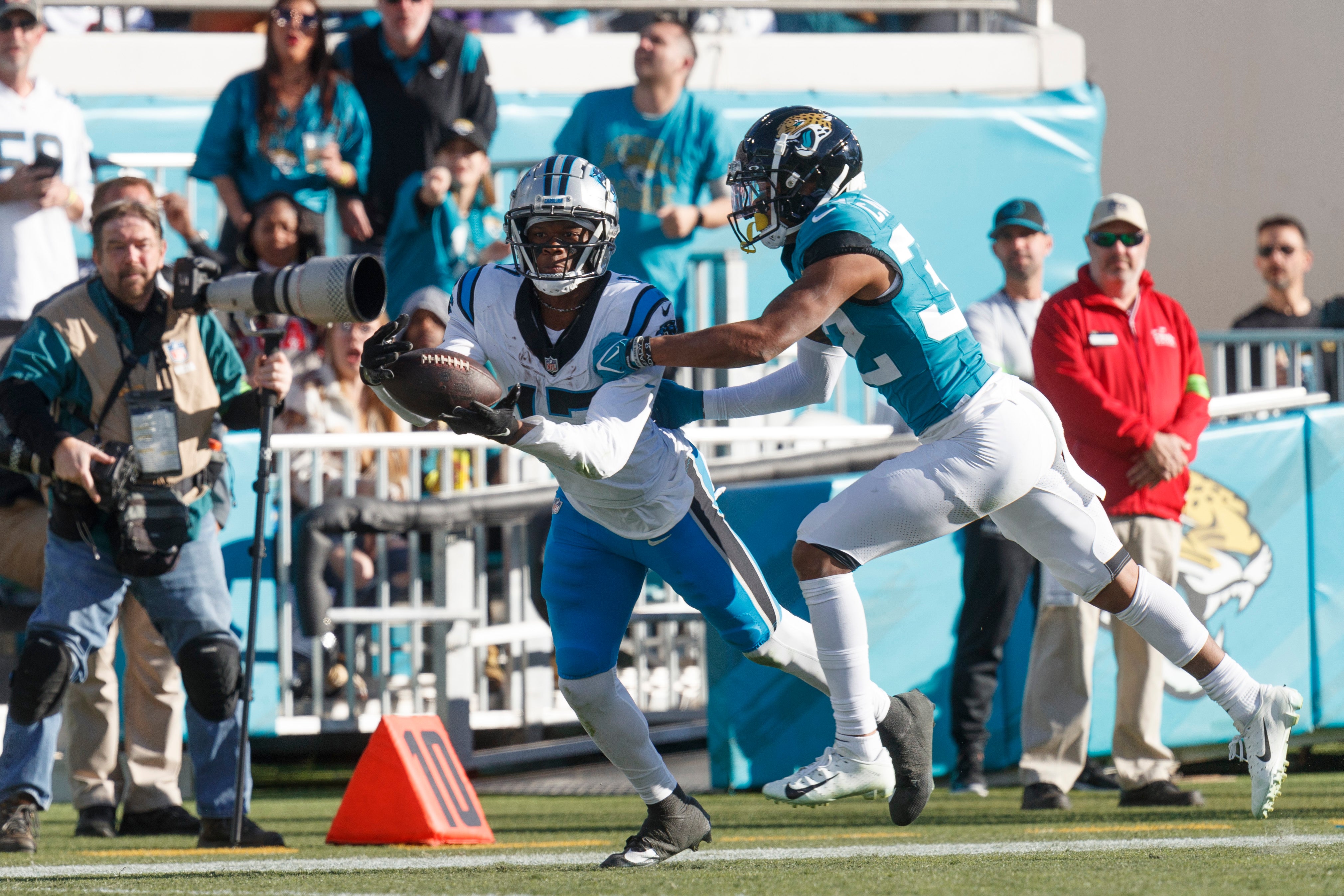 Dec 31, 2023; Jacksonville, Florida, USA; Carolina Panthers wide receiver Jonathan Mingo (15) drops a pass under pressure from corner back Tyson Campbell (32) during the fourth quarter at EverBank Stadium. Mandatory Credit: Morgan Tencza-USA TODAY Sports