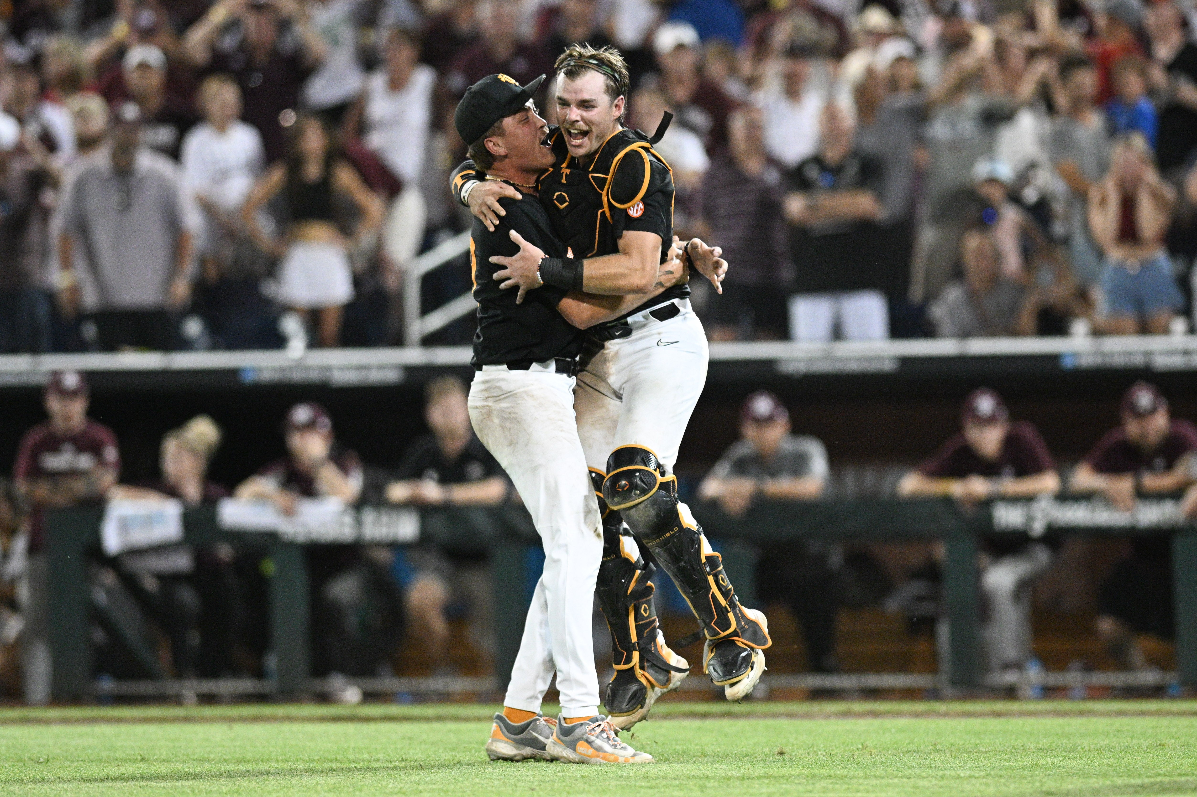 Jun 24, 2024; Omaha, NE, USA; Tennessee Volunteers pitcher Aaron Combs (28) and catcher Cal Stark (10) celebrate the win against the Texas A&M Aggies at Charles Schwab Field Omaha.