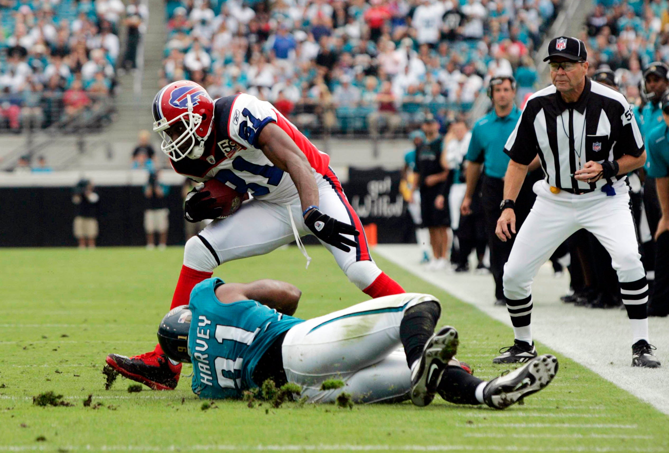 Buffalo Bills wide receiver Terrell Owens (81) breaks a tackle attempt by Jacksonville Jaguars defensive end Derrick Harvey (91) at Jacksonville Municipal Stadium.