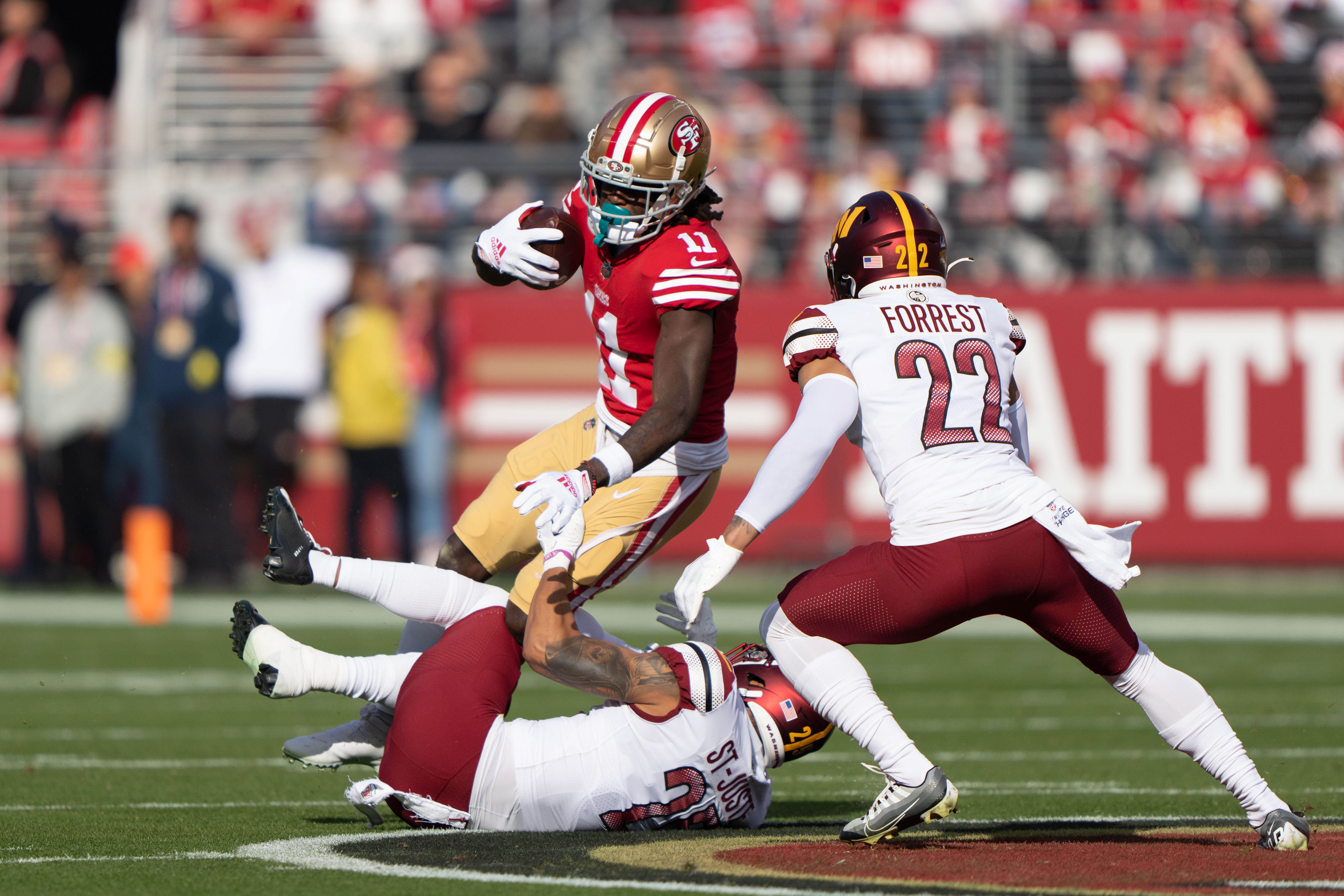 Dec 24, 2022; Santa Clara, California, USA; Washington Commanders cornerback Benjamin St-Juste (25) and safety Darrick Forrest (22) attempt to tackle San Francisco 49ers wide receiver Brandon Aiyuk (11) during the first quarter at Levi's Stadium.