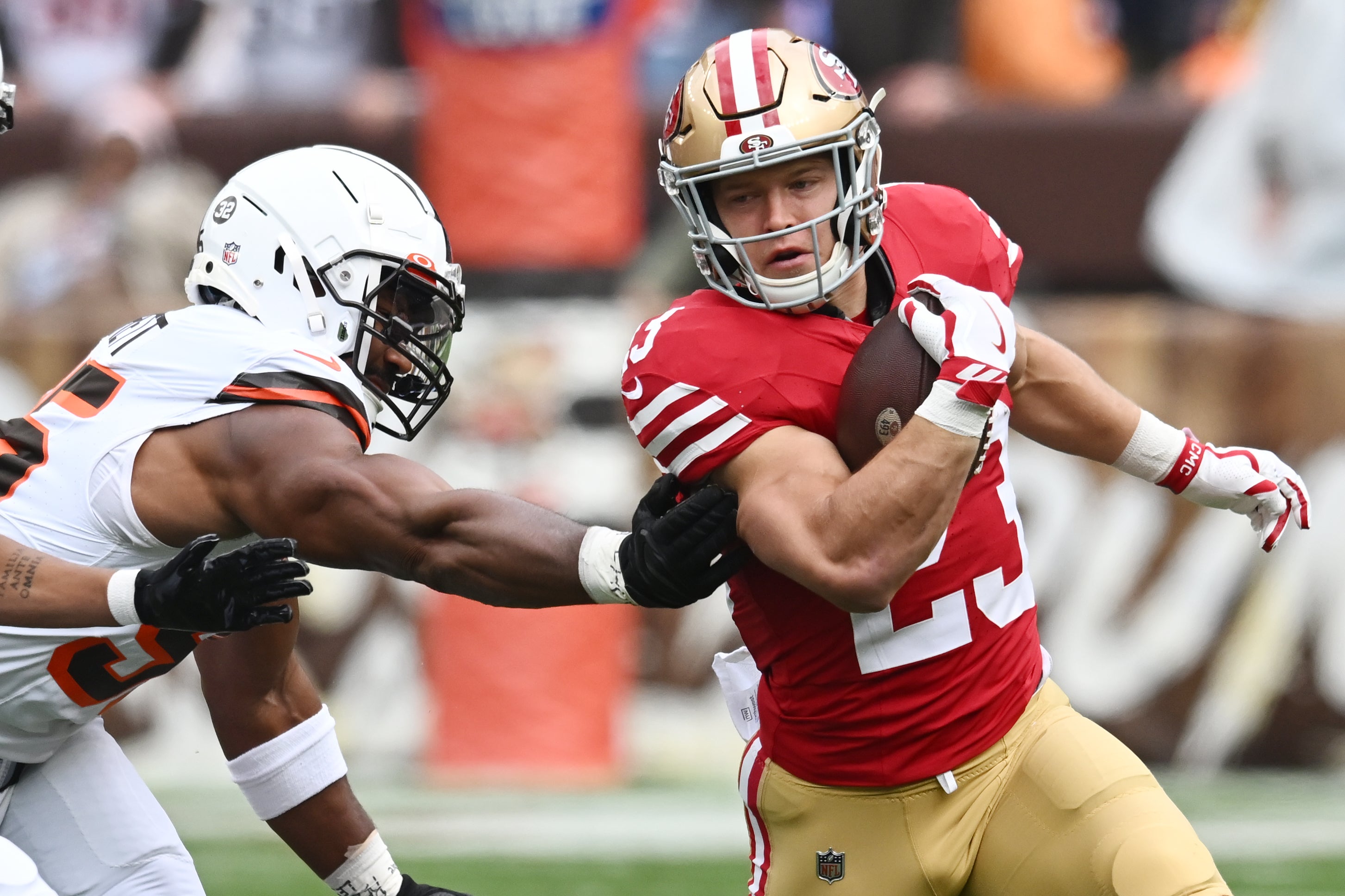 Oct 15, 2023; Cleveland, Ohio, USA; San Francisco 49ers running back Christian McCaffrey (23) runs from Cleveland Browns defensive end Myles Garrett (95) during the first half at Cleveland Browns Stadium.