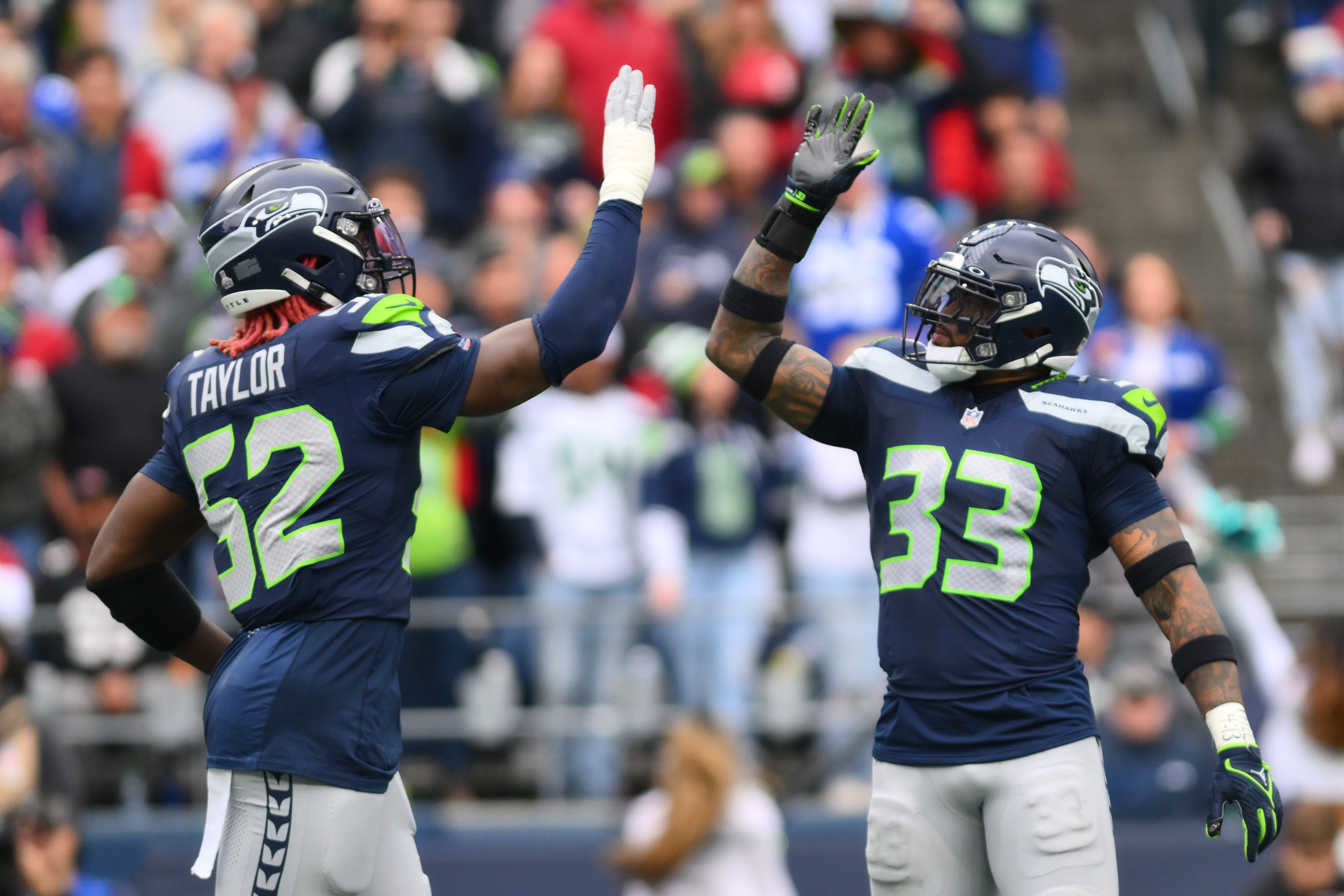 Seattle Seahawks linebacker Darrell Taylor (52) and safety Jamal Adams (33) celebrate after the defense made a play against the Arizona Cardinals during the first half at Lumen Field.