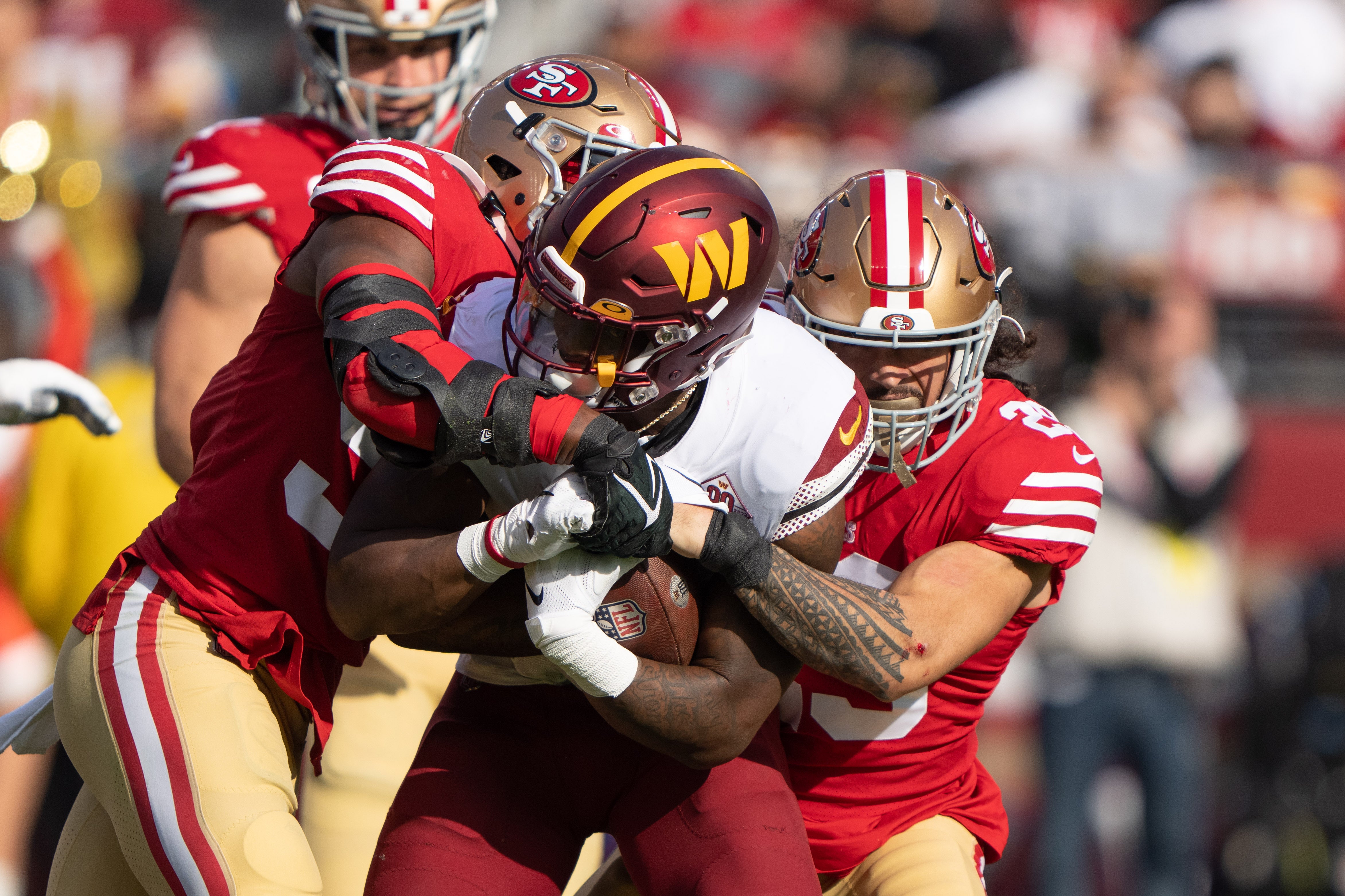 Dec 24, 2022; Santa Clara, California, USA; San Francisco 49ers linebacker Dre Greenlaw (57) and safety Talanoa Hufanga (29) tackle Washington Commanders running back Brian Robinson Jr. (8) during the first quarter at Levi's Stadium.